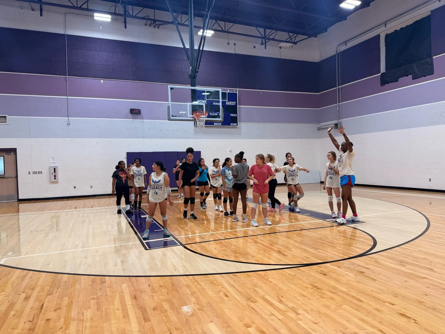 Athletes practicing volleyball skills together at camp.