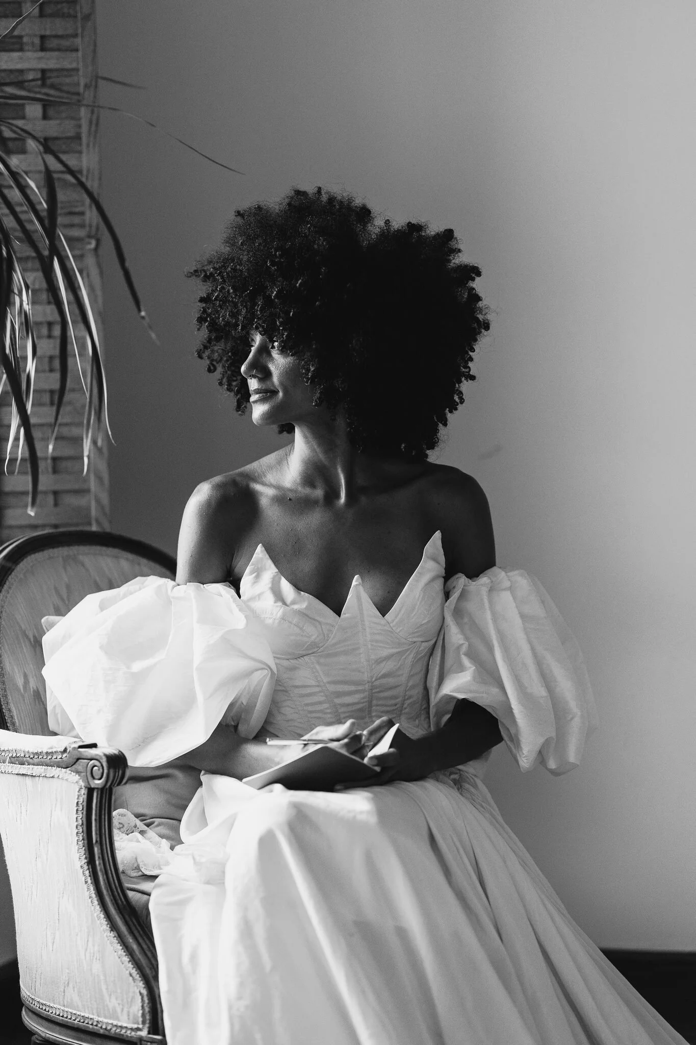 Bride writing her vows and looking at the window