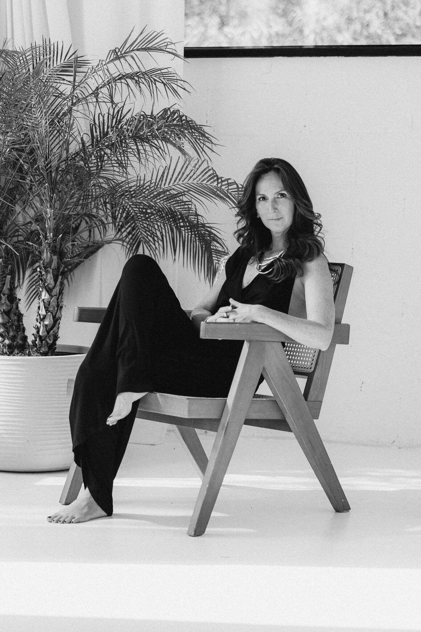 woman posing on a rattan chair and looking at the camera