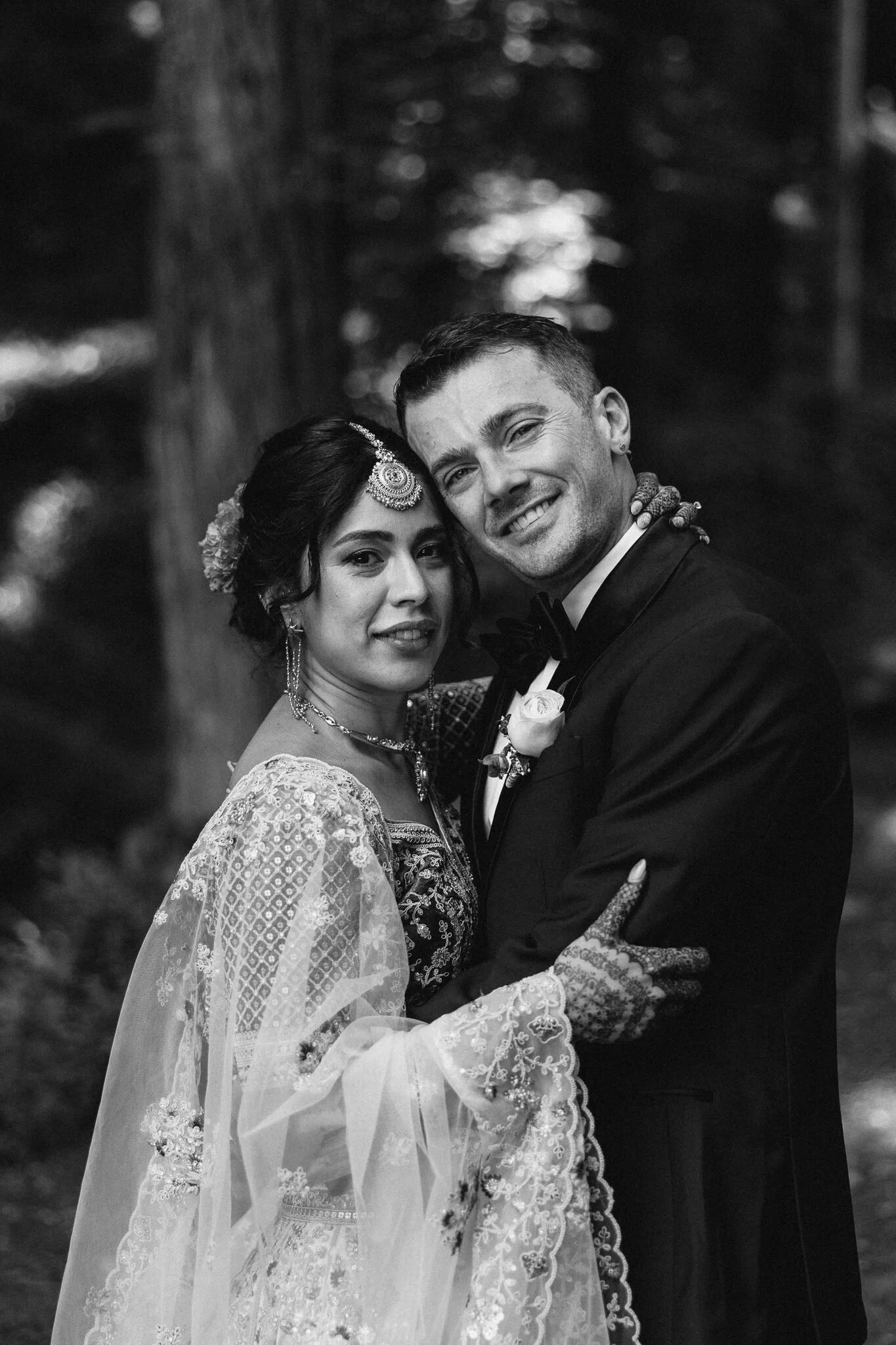 Bride and Groom embracing and looking at the camera