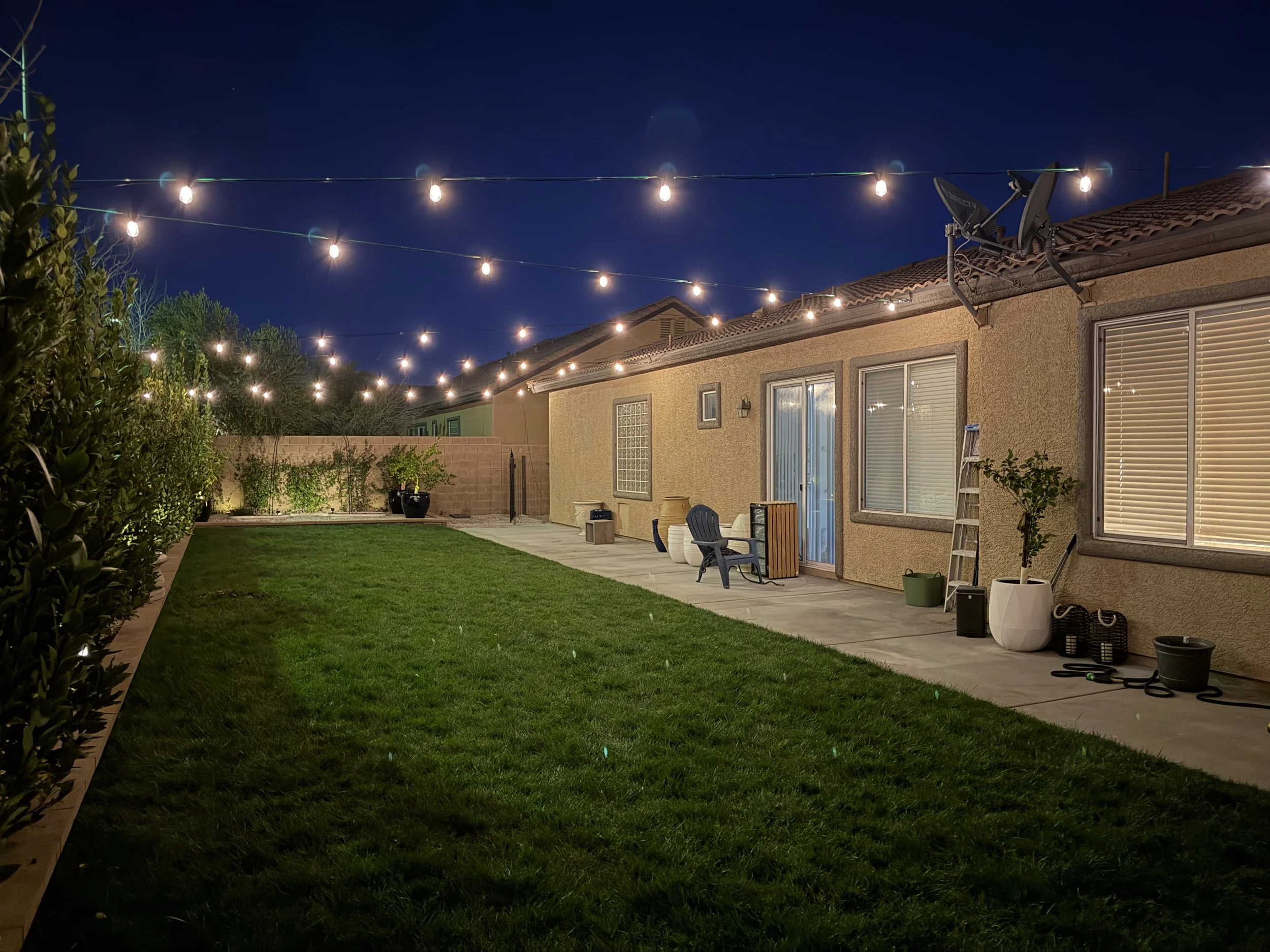 Bistro lighting installation in Las Vegas backyard patio with warm outdoor lighting