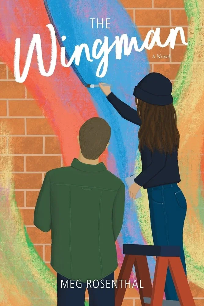Two people, a man and a woman, painting a colorful mural on a brick wall. The woman is on a ladder, wearing a black hat and dark clothing, with long brown hair. The man, with short hair and a green jacket, is standing and observing. The mural features a rainbow and the title "The Winyman" by Meg Rosenthal.