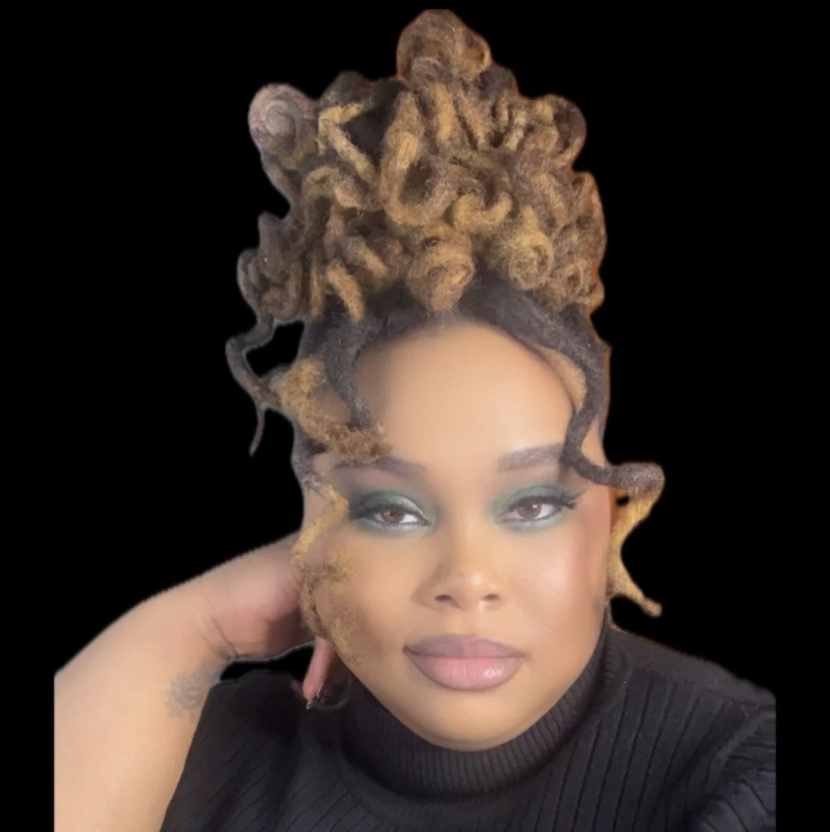 A woman with makeup and medium skin tone, resting her head on her hand, with dreadlocked hair styled in a large updo.