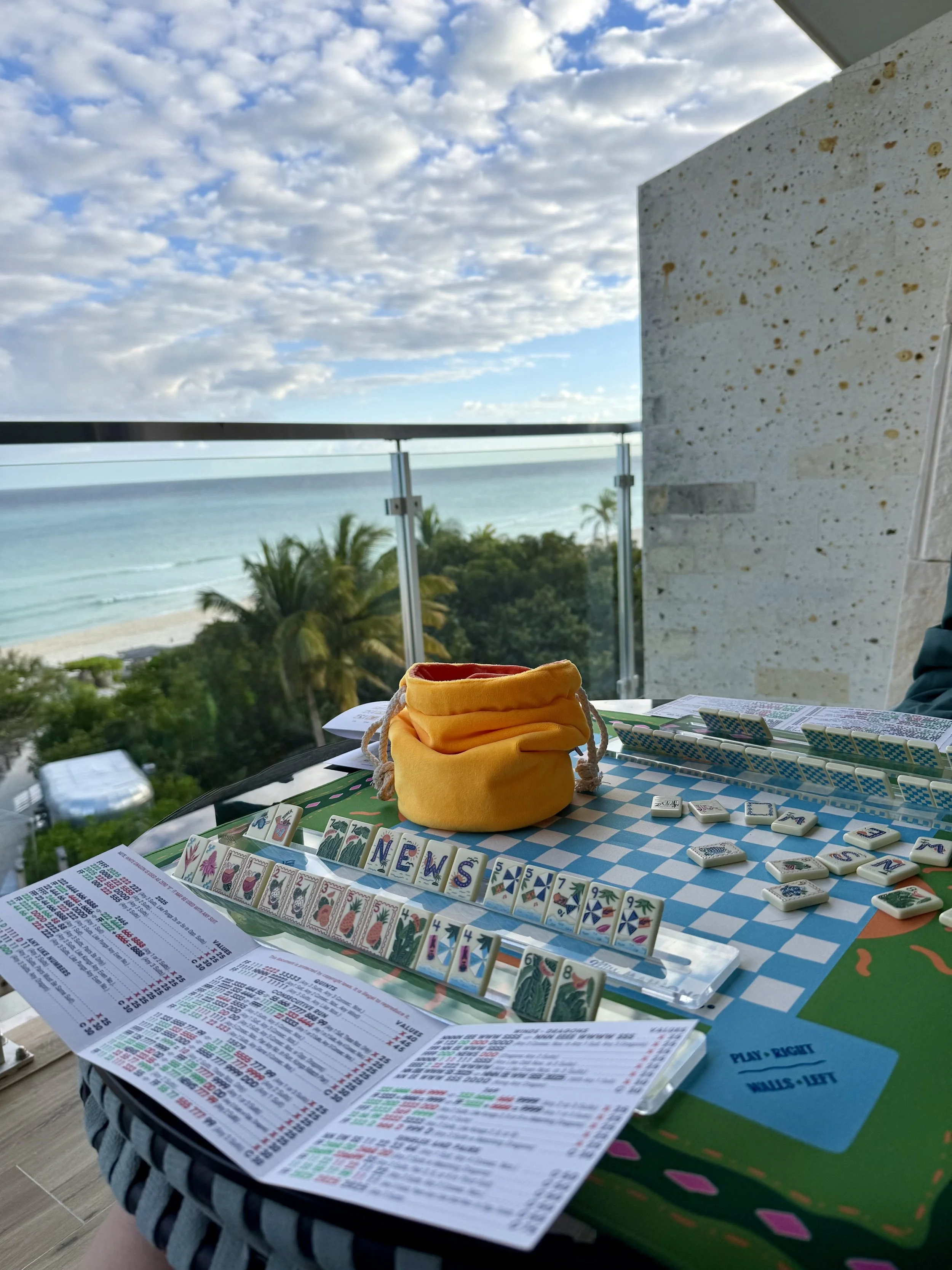 social mahjong game on the balcony overlooking blue water and skys