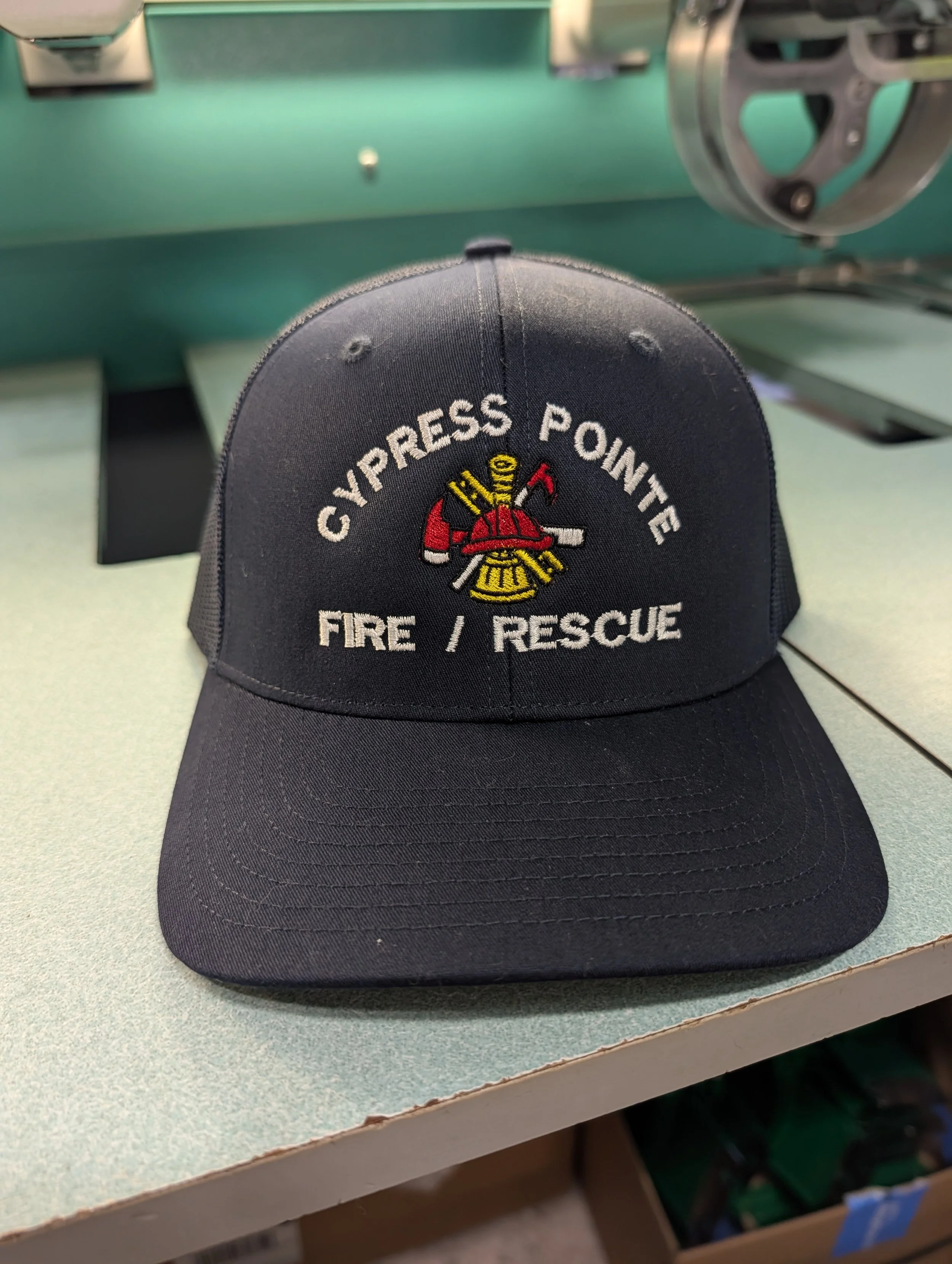 Black baseball cap with embroidered patch reading 'CYPRESS POINT FIRE / RESCUE' and a fire helmet and tools design.
