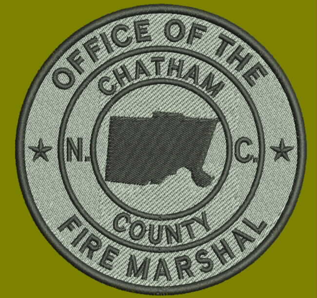 Patch of the Chatham County Fire Marshal's Office in North Carolina. The patch features a dark outline of the state of North Carolina with a fire truck silhouette in the center, and text around the border.