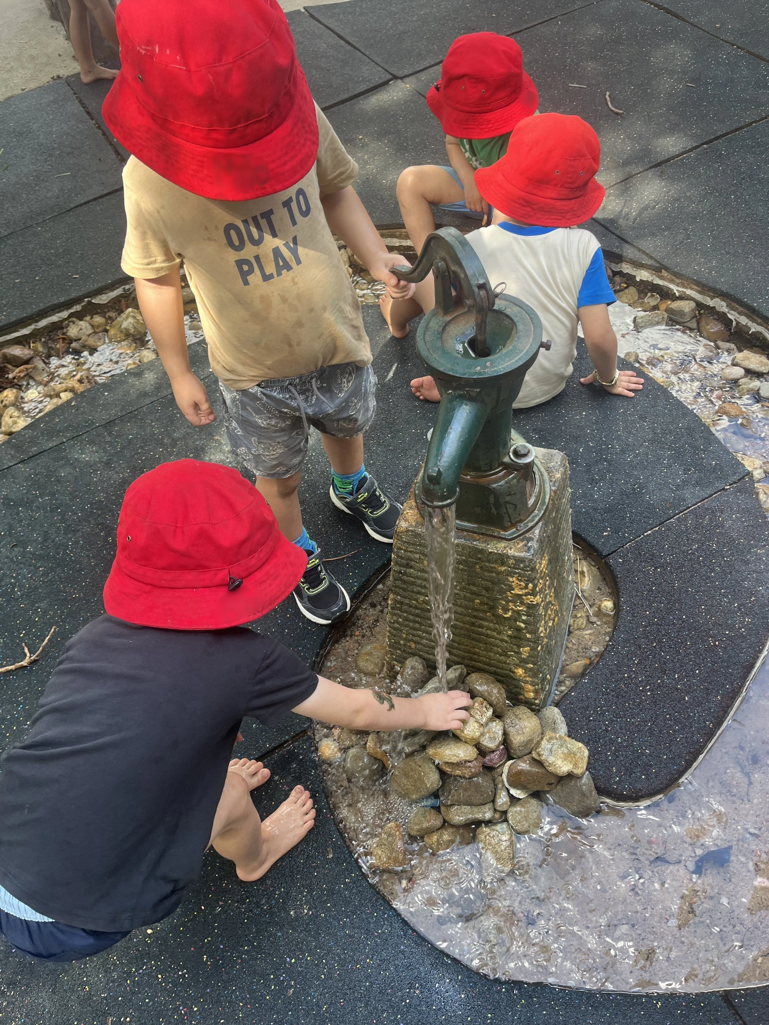children playing with water pump