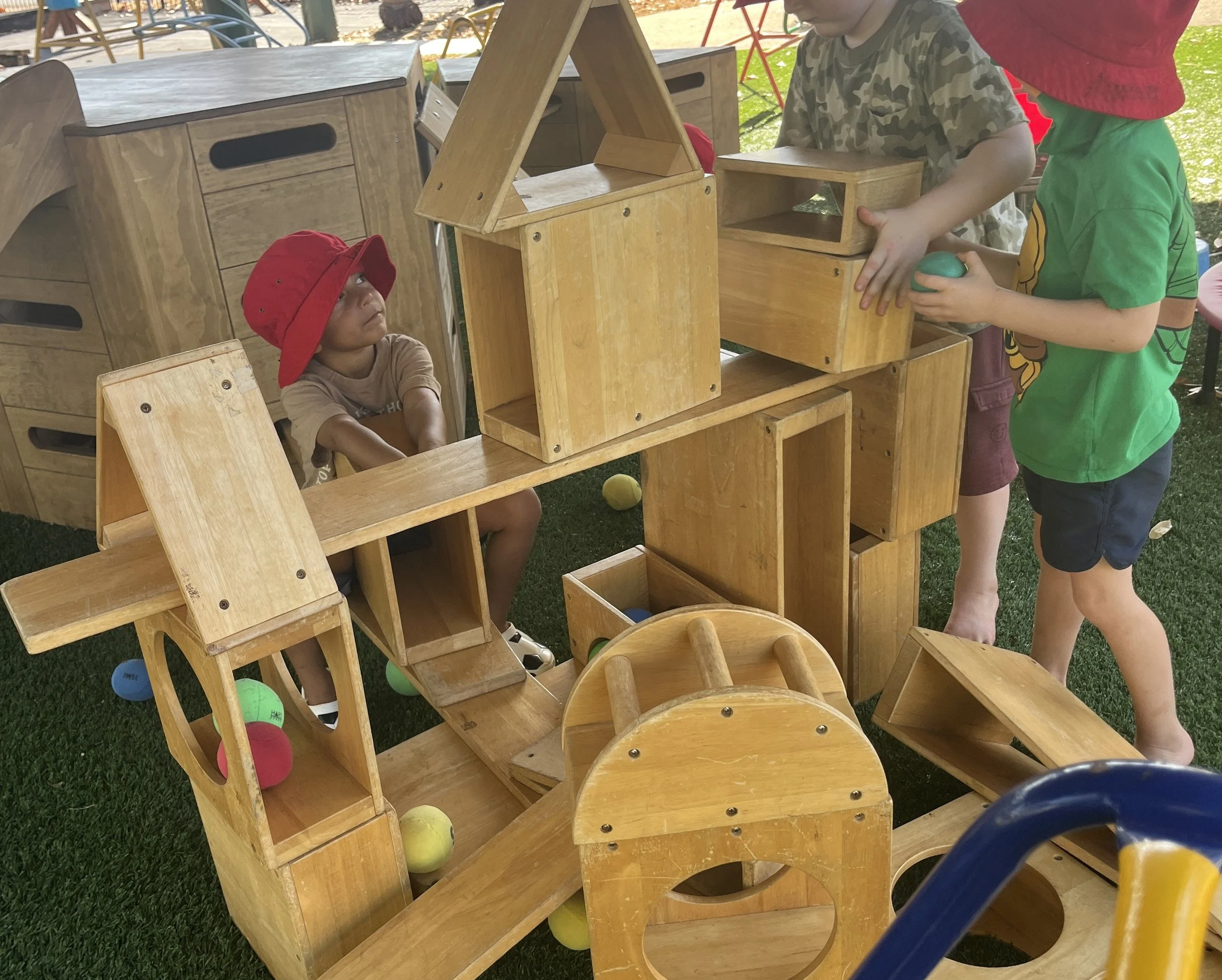 Children building with large outside wooden blocks