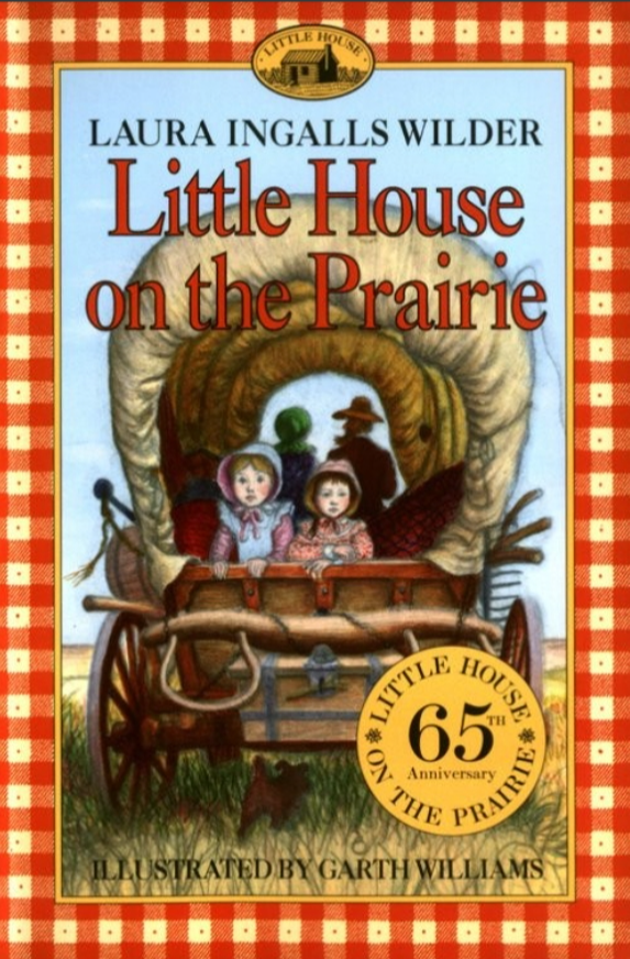 Book cover of 'Little House on the Prairie' by Laura Ingalls Wilder, illustrated by Garth Williams. The cover features a family riding in a covered wagon in a prairie setting, with a dog in front. The border has a red and white checkered pattern, and there are logos indicating the 65th anniversary of Little House on the Prairie.