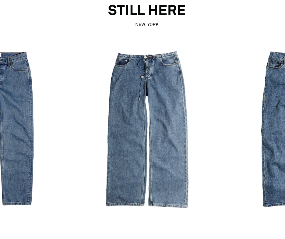 Pair of blue jeans, centered on a white background, with the text "STILL HERE" and "NEW YORK" above.