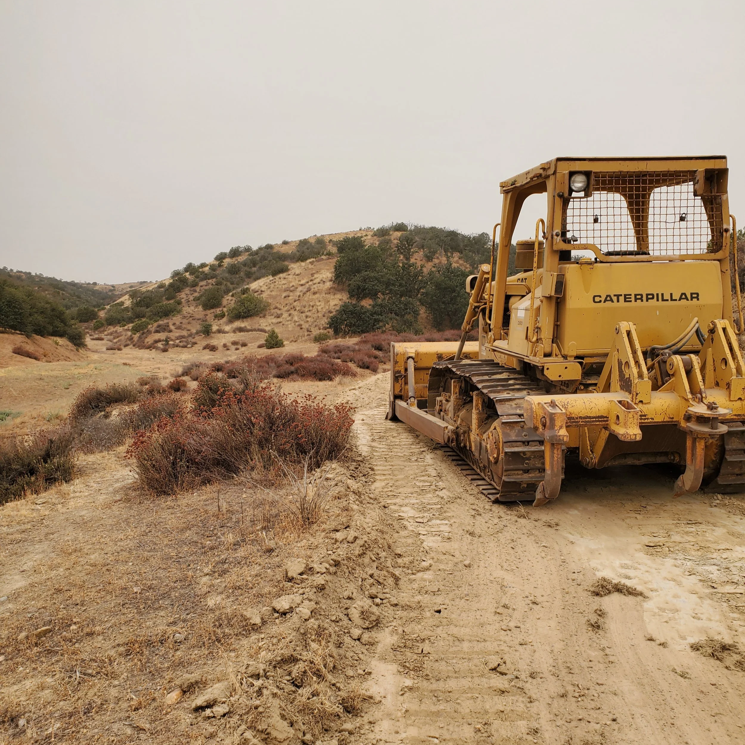 Bulldozer performing dirt work and land clearing in Pozo California.