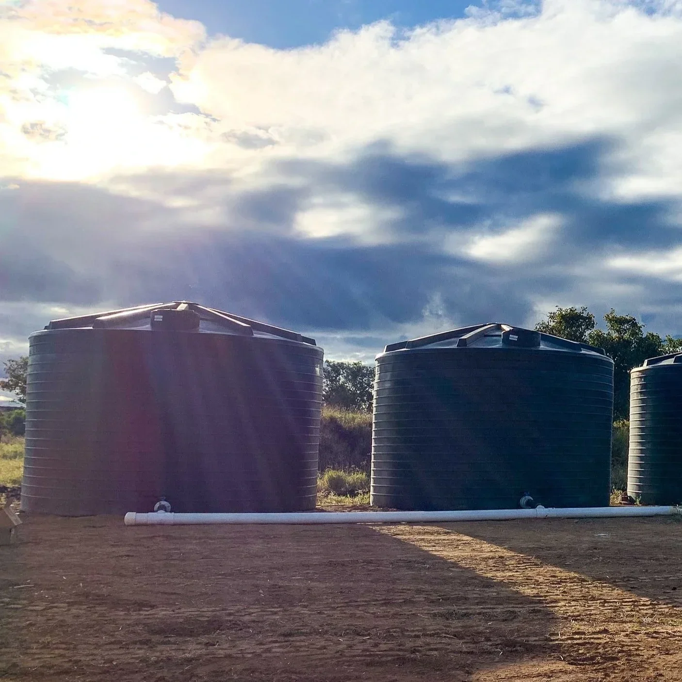 Farm irrigation setup with water storage tanks for agriculture use.
