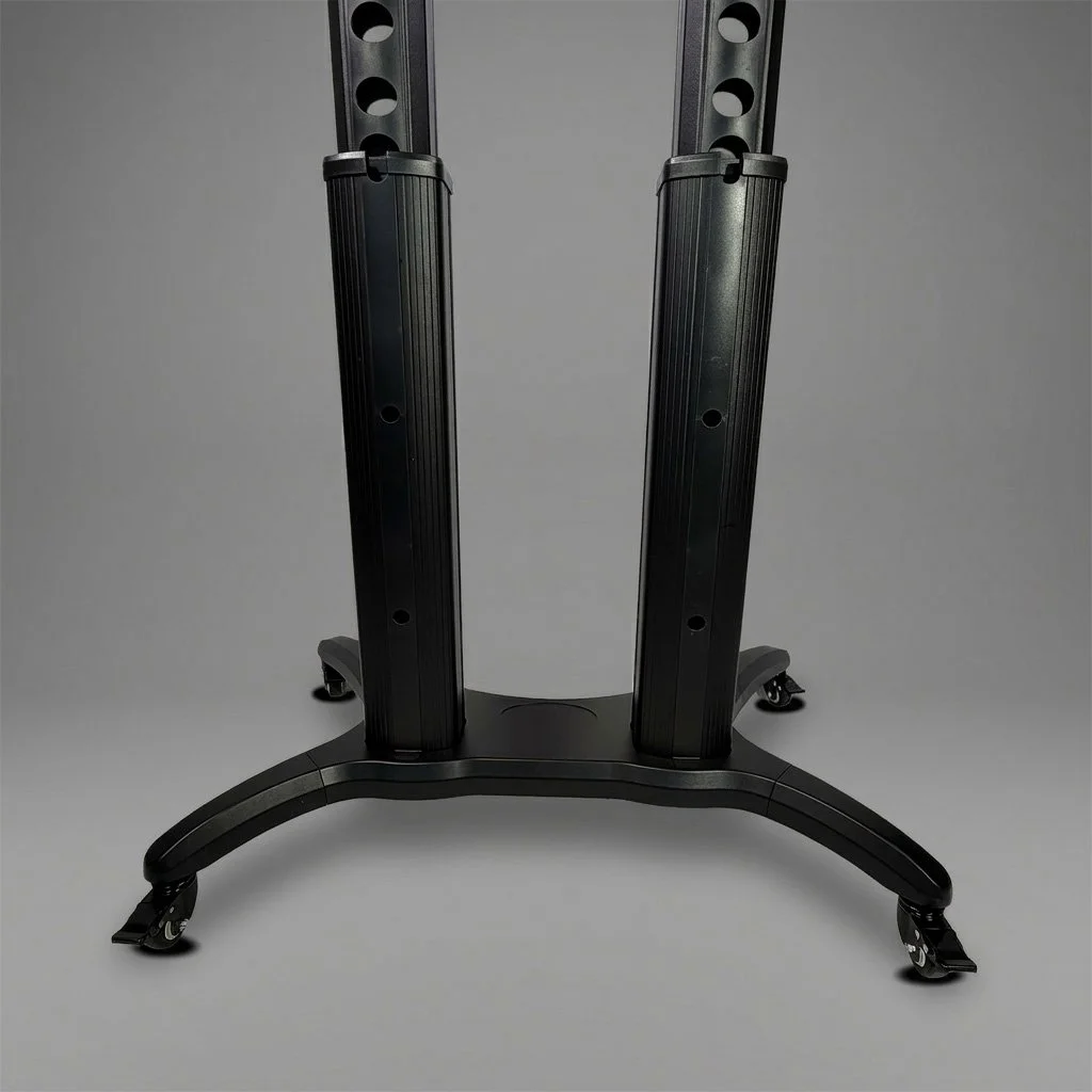Close-up of an adjustable black metal equipment stand with wheels on a gray background.