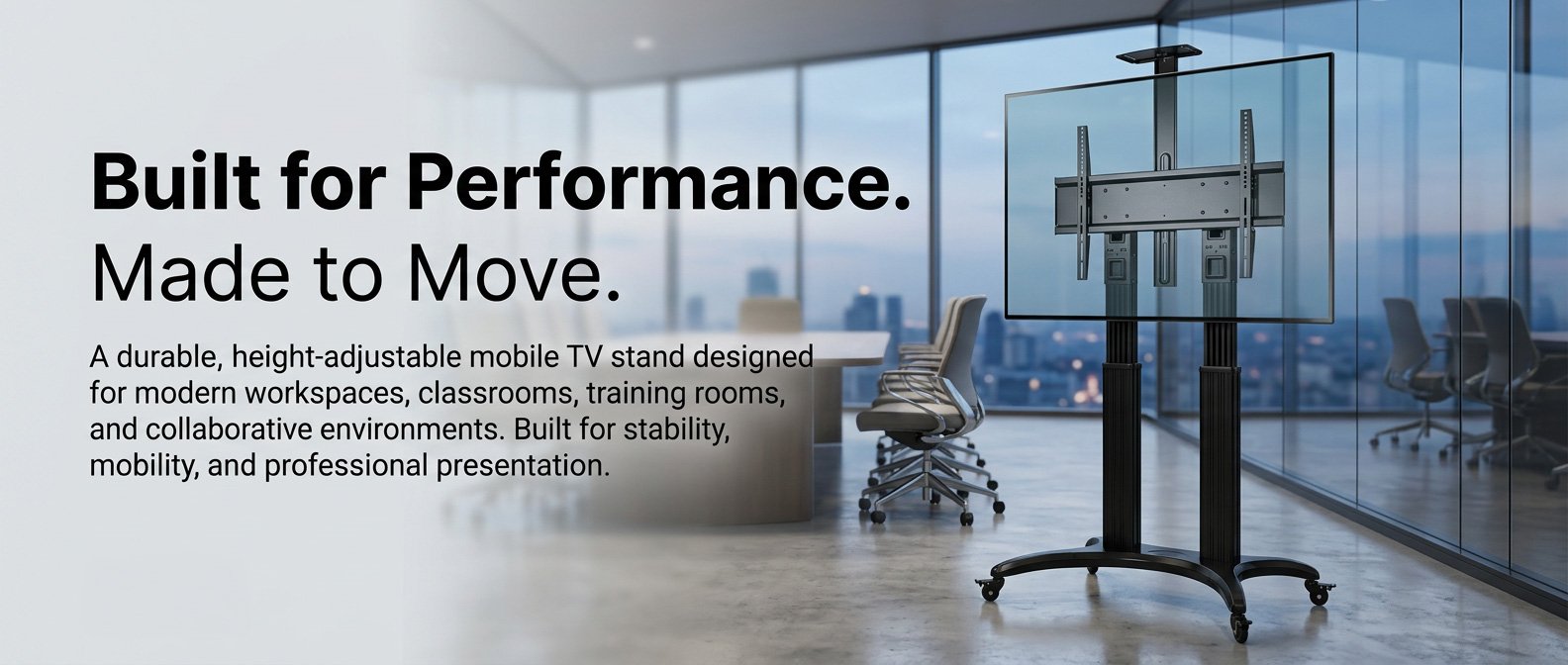 A mobile height-adjustable TV stand with a large flat screen in a modern office space with glass walls and city views.