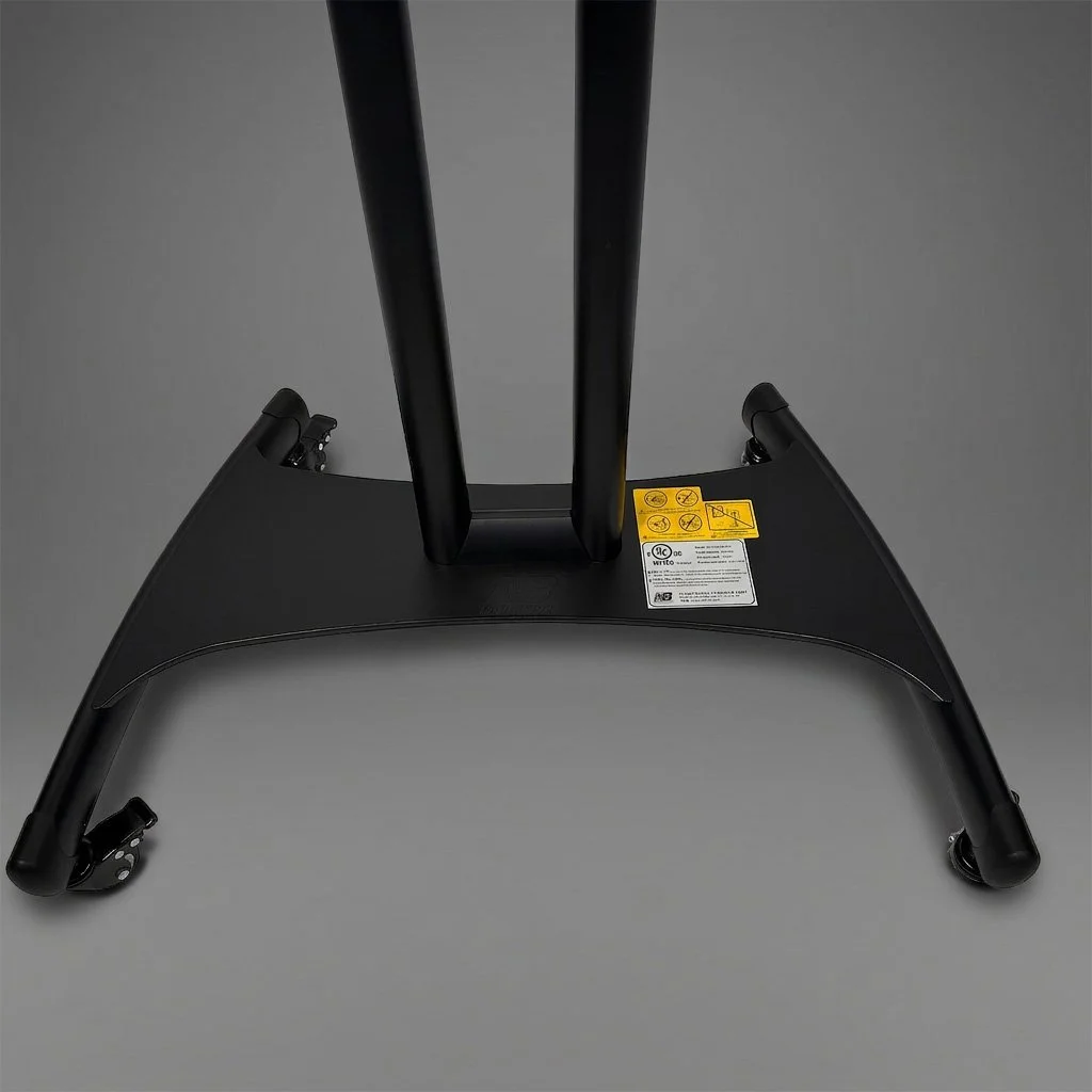 The image shows the bottom of a black folding chair with label stickers, set against a gray background.