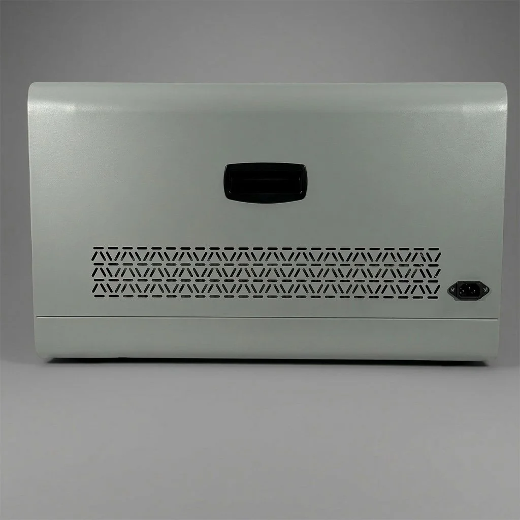 View of the back of a small electronic device with a black handle, ventilation holes, and a power port, against a gray background.