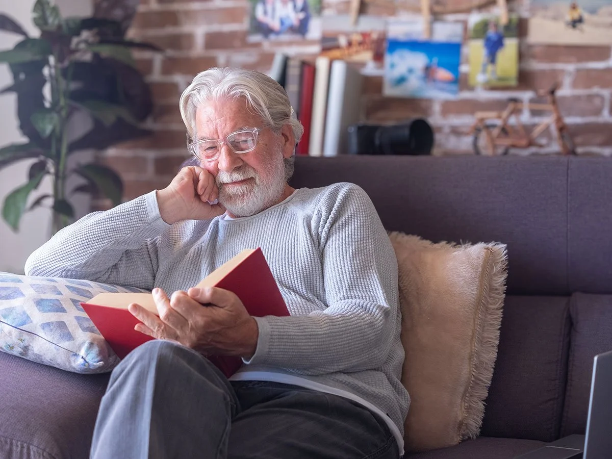 Man reading available resources at the Tide & Times dementia friendly café.