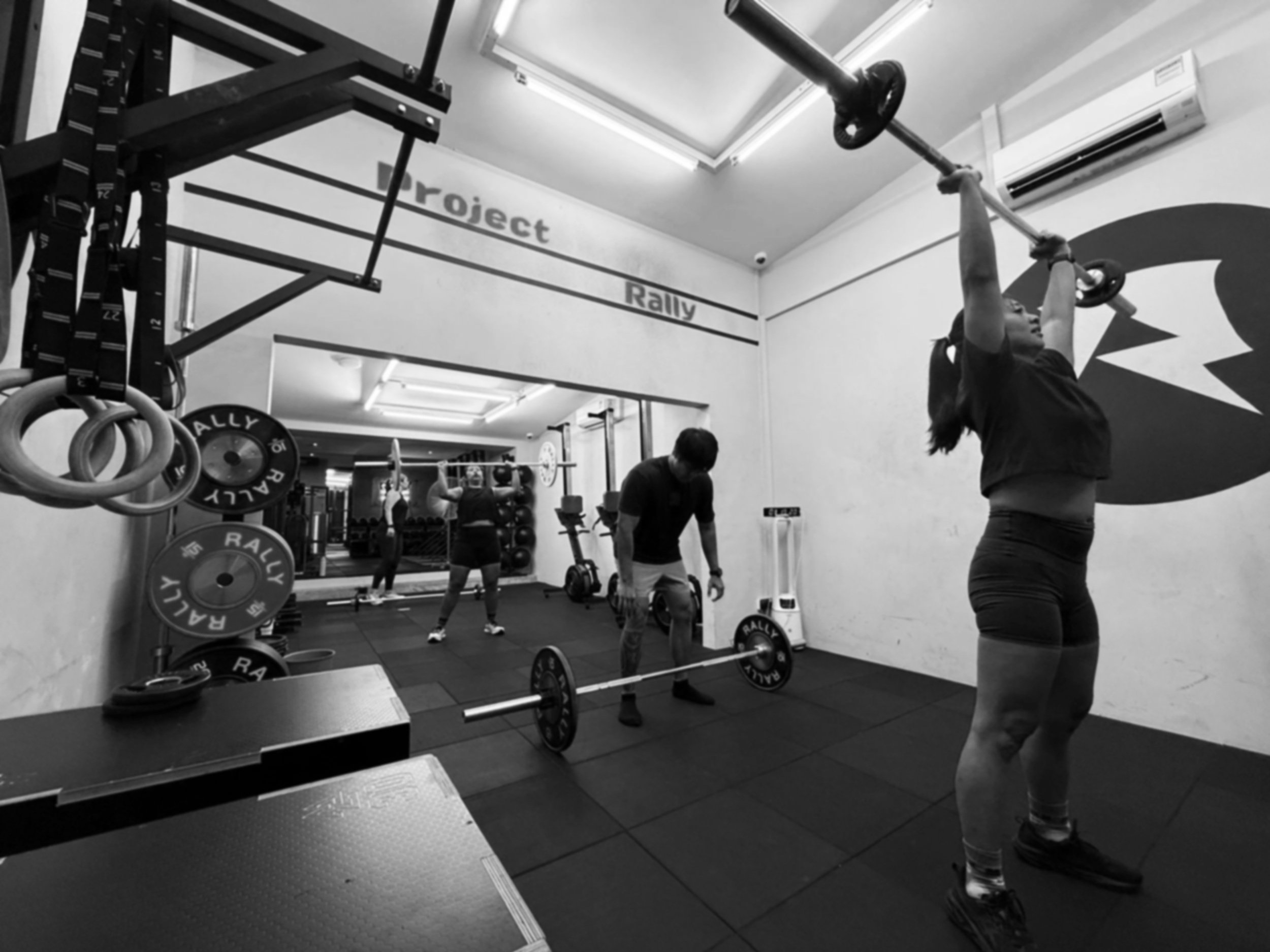 Member performing barbell overhead lift in a strength training class at a Balestier Singapore gym