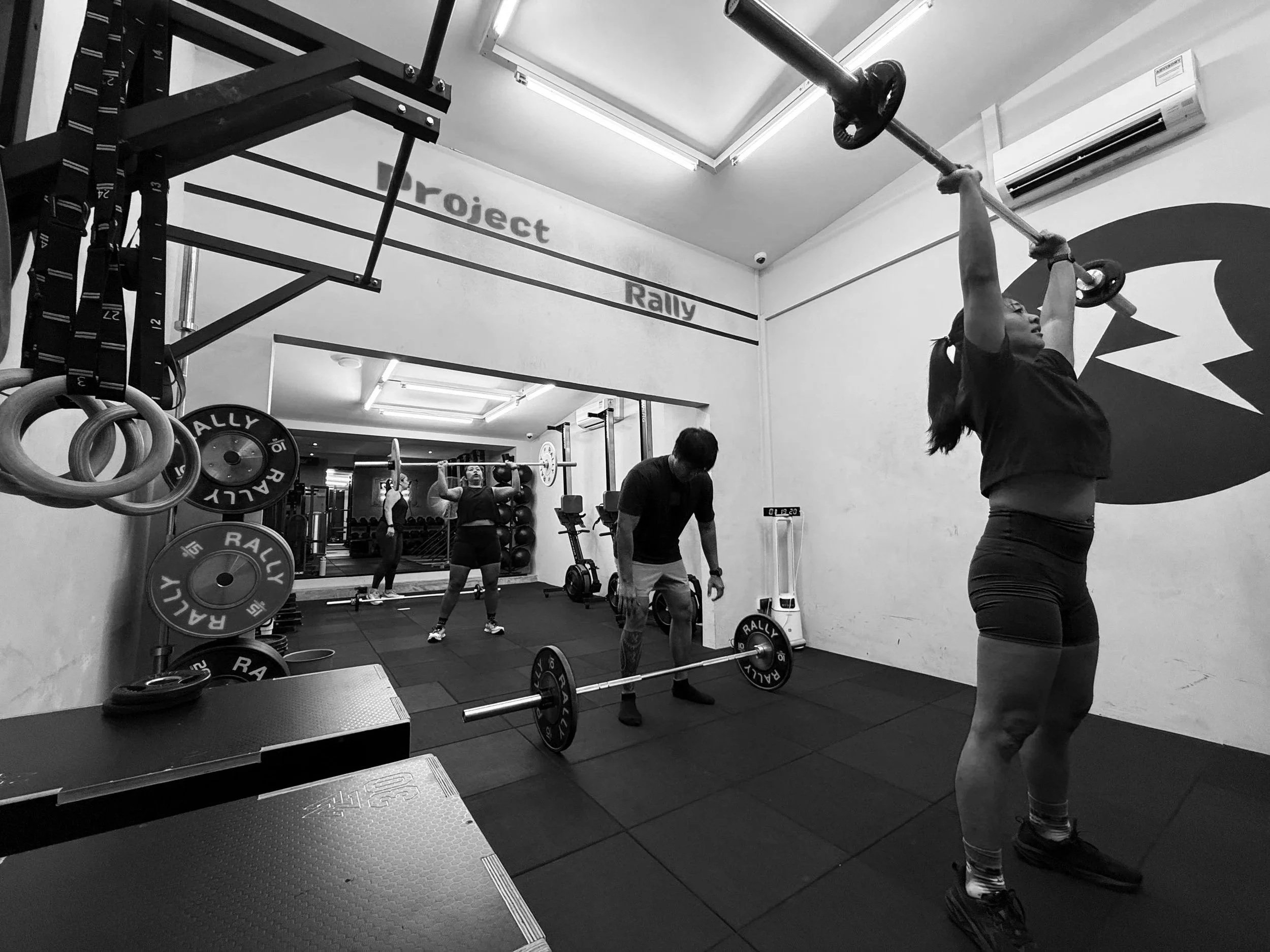 Member performing barbell overhead lift in a strength training class at a Balestier Singapore gym