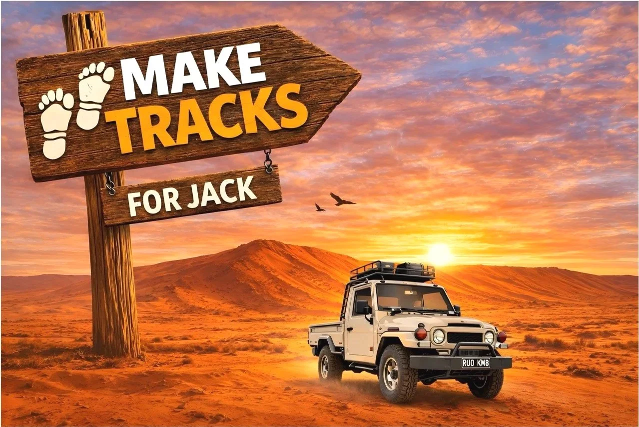 A white off-road vehicle driving in a desert landscape during sunset, with mountains and a colorful sky in the background. A wooden sign with the text 'Make Tracks for Jack' and footprint icons is in the foreground.