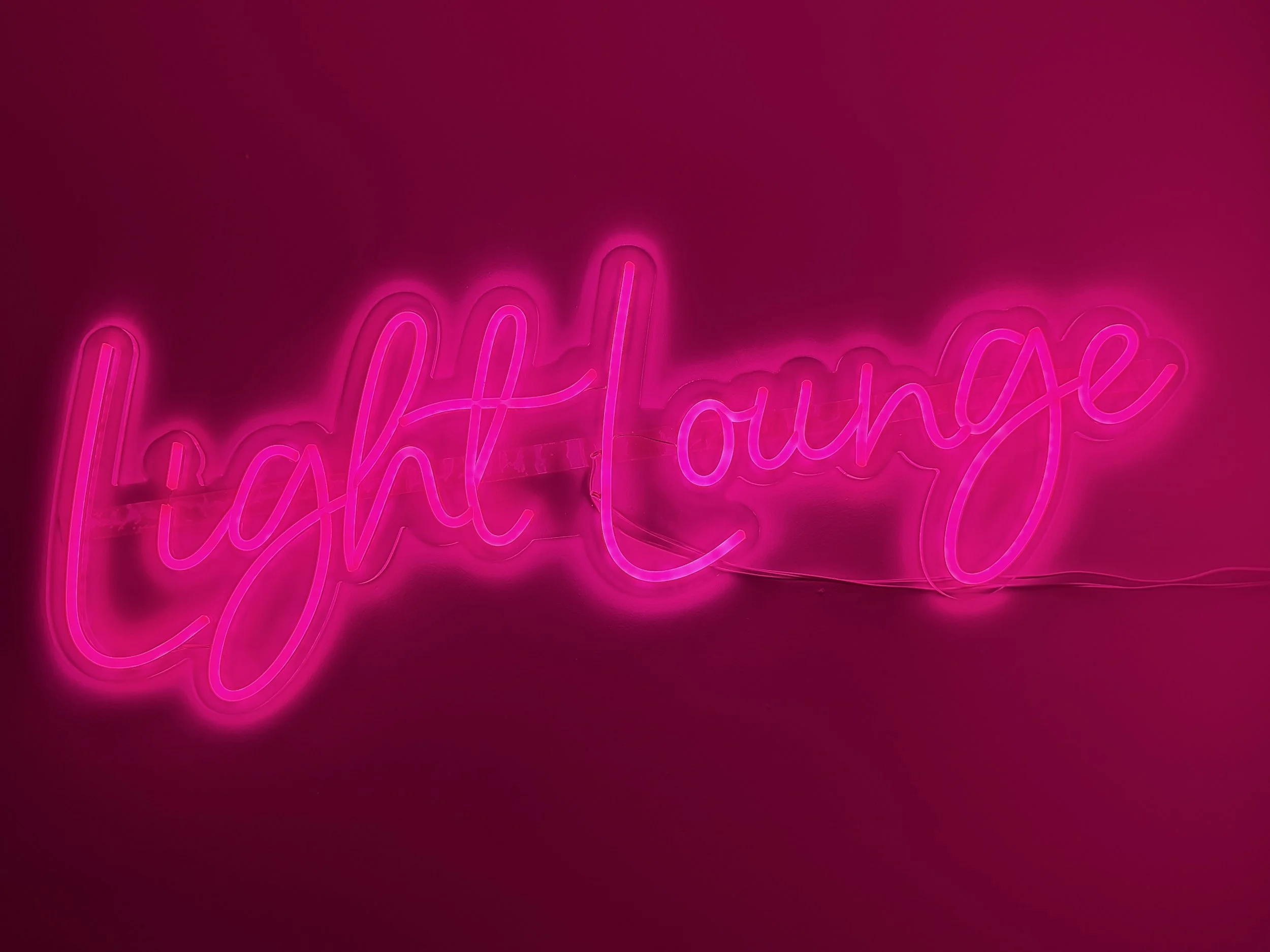 An image showing the neon LightLounge sign in the SkinFirst Warrington Dermalux Light Lounge