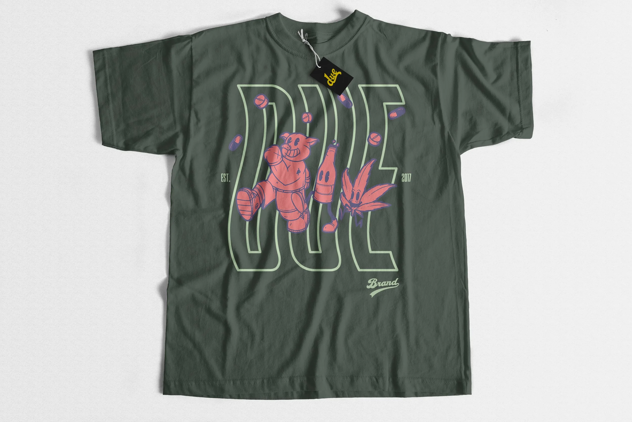 Green T-shirt with graphic of cartoon pig, carrot, and pills, and text 'DUE' and '2023'.