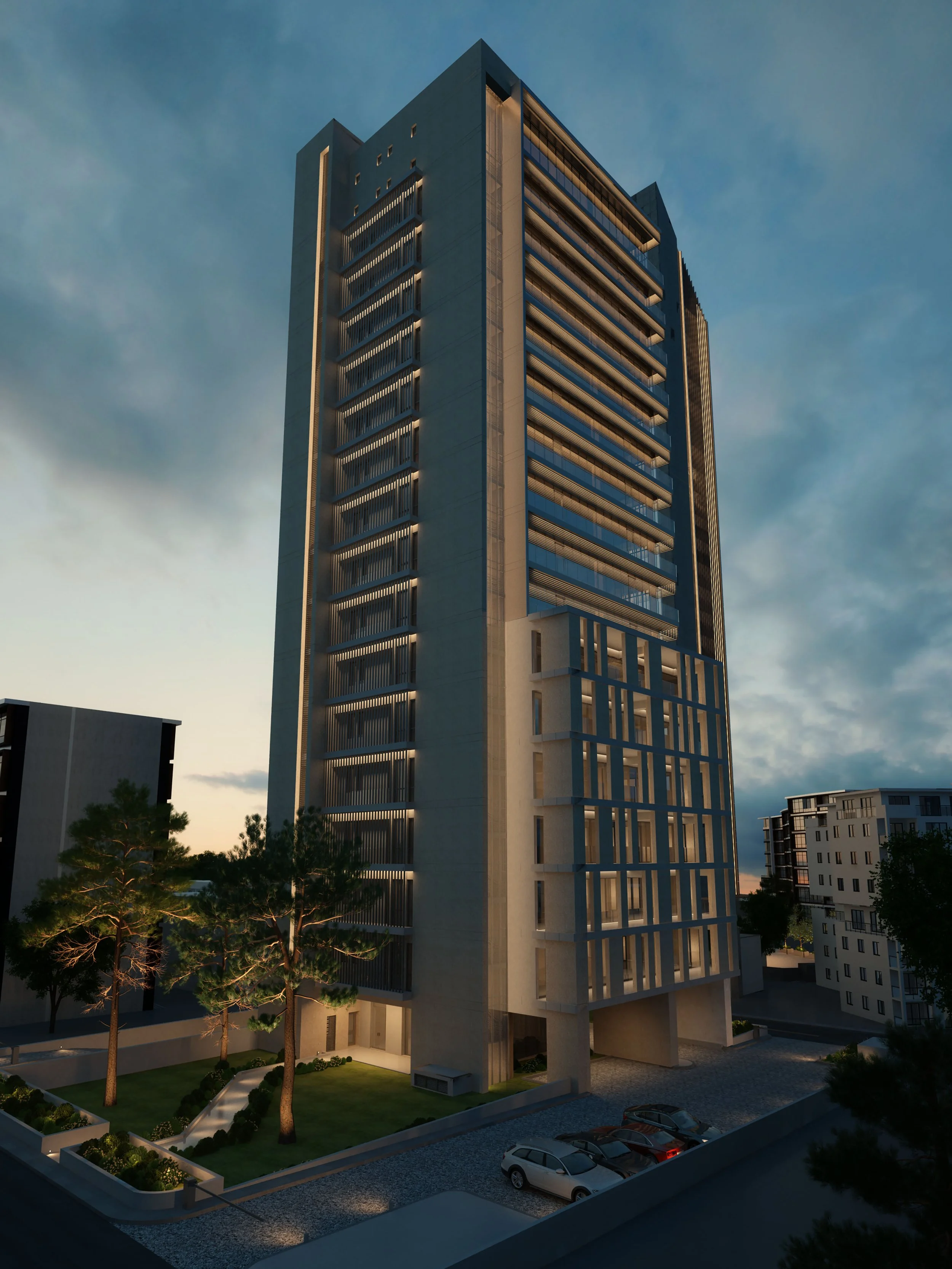 Nighttime view of a modern high-rise building with illuminated balcony railings and a landscaped garden area with trees and grass in the foreground. Several cars are parked in a lot nearby, with other residential buildings visible in the background.