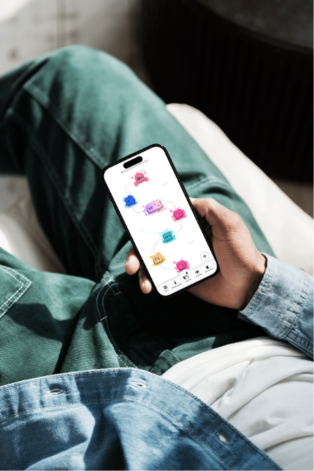 Person hält Smartphone mit bunte Robot-Icons auf dem Bildschirm, sitzt auf einem Bett.