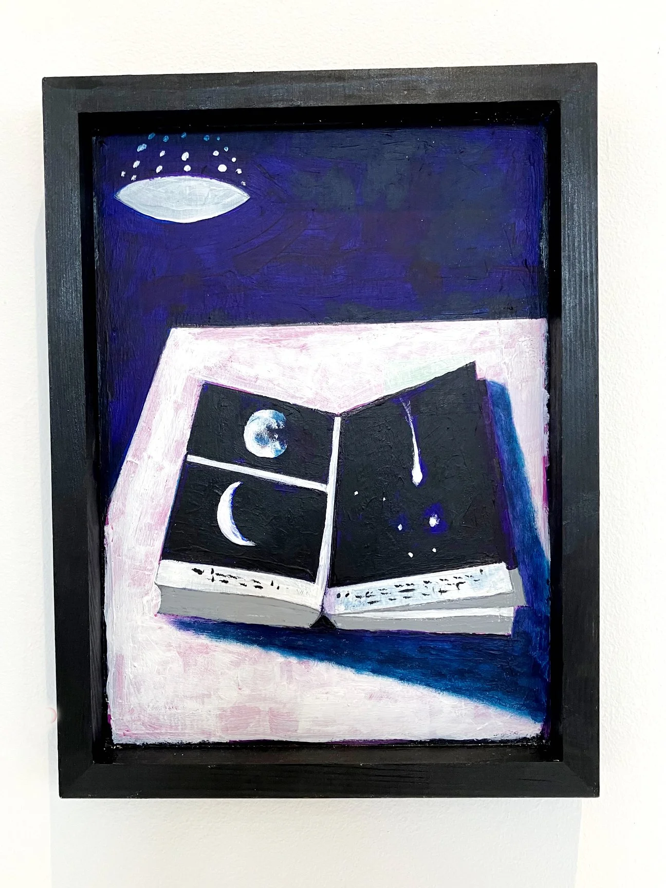 Painting of an open book with images of the moon, crescent moon, and stars on its pages, under a dark blue night sky with a white lamp hanging overhead.