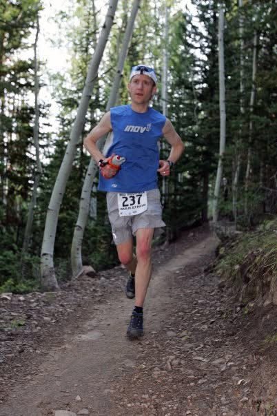 Kevin running in an ultra race in the woods on a trail.
