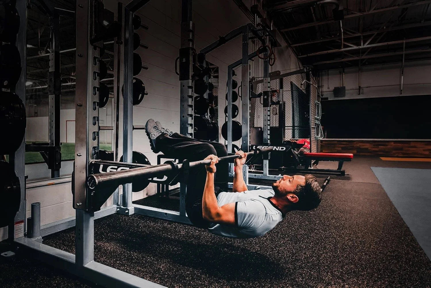 Man pulling himself up on a weight rack