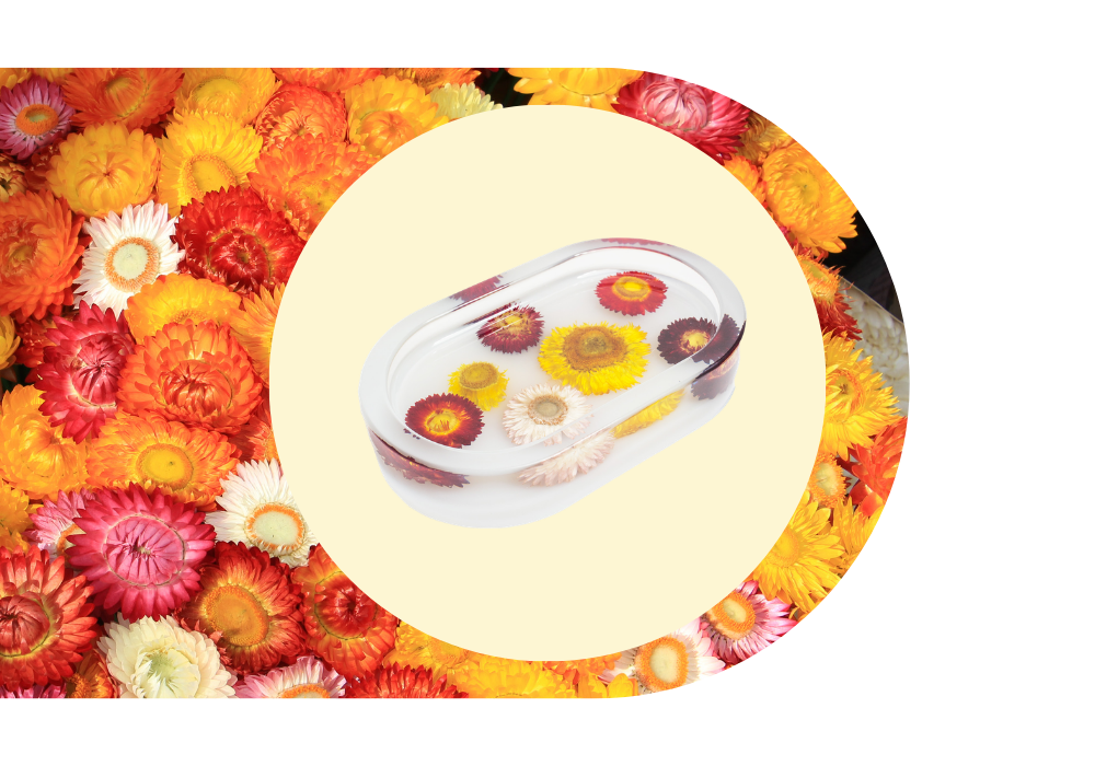 A trinket tray with floating dried flowers, surrounded by a colorful assortment of dried flowers.