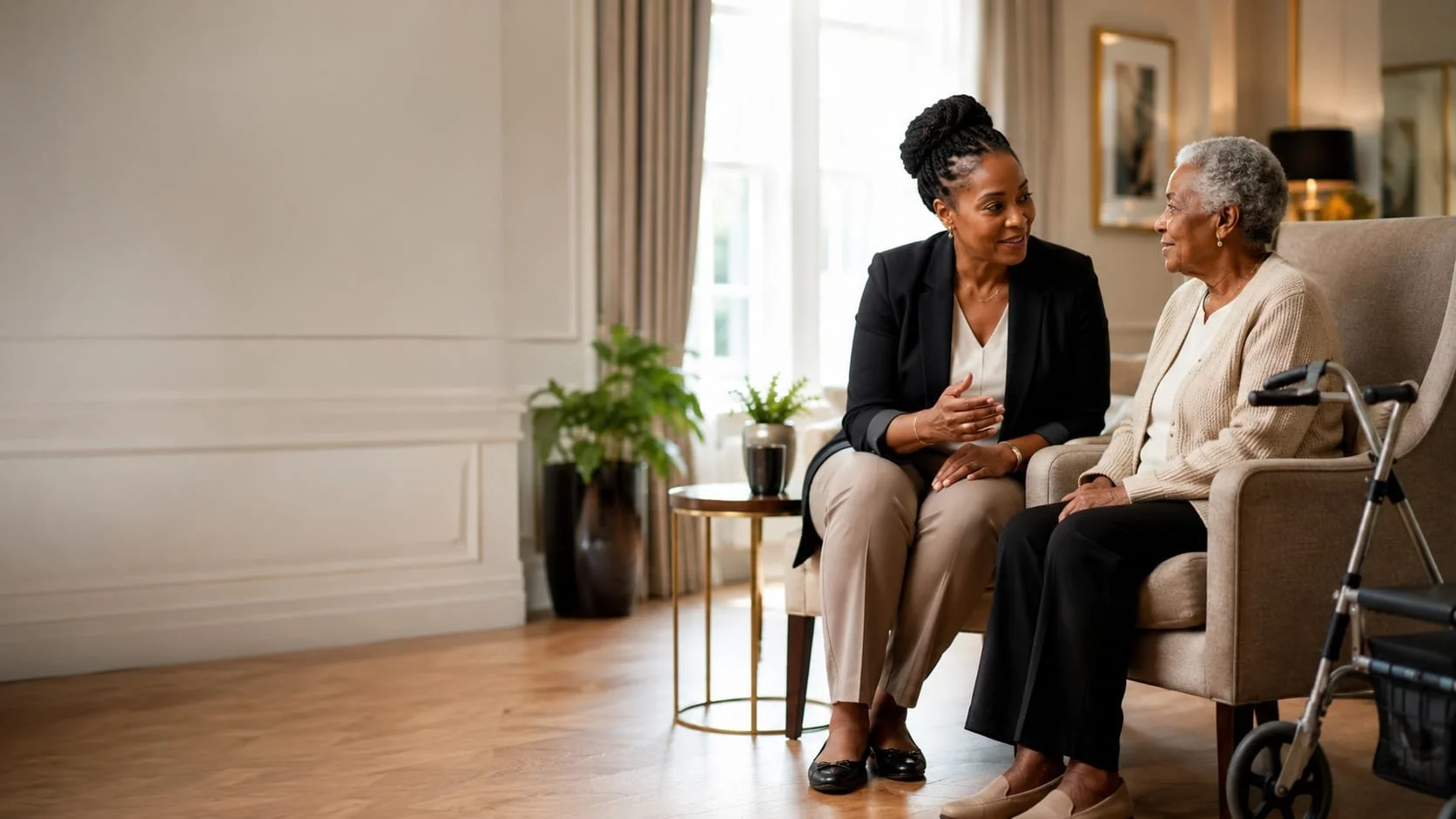 A caregiver helping an elderly woman in a wheelchair in a bright, cozy room.