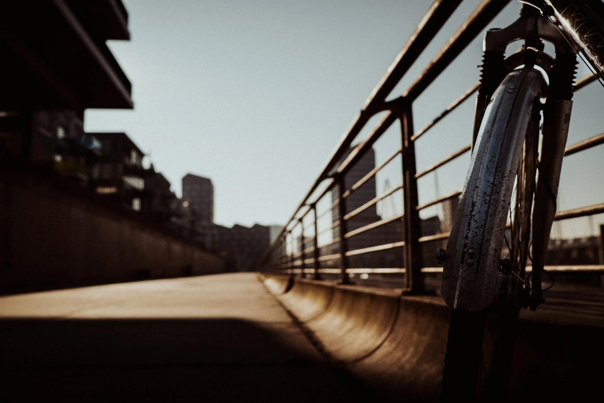 Fahrrad an einem metallenen Geländer mit Blick auf die Überseestadt in Bremen, sonniges Morgenlicht