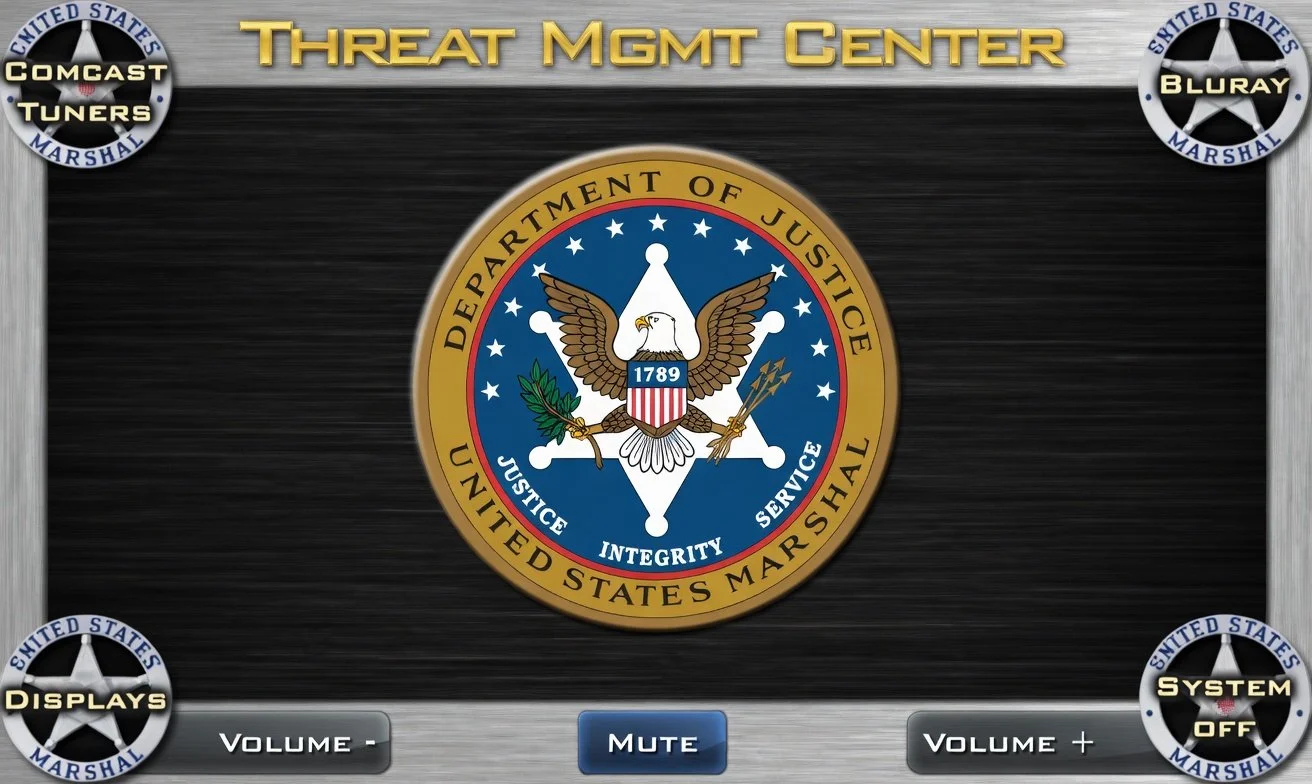 Digital interface titled "Threat Mgmt Center" with four circular badges around a central emblem. The badges read "COMCAST TUNERS," "BLURAY SYSTEM OFF," "DISPLAYS," and "SYSTEM OFF." The central emblem is the United States Department of Justice seal with an eagle, shield, and other symbols, surrounded by the words "Department of Justice," "United States Marshal," and the motto "Justice, Integrity, Service."