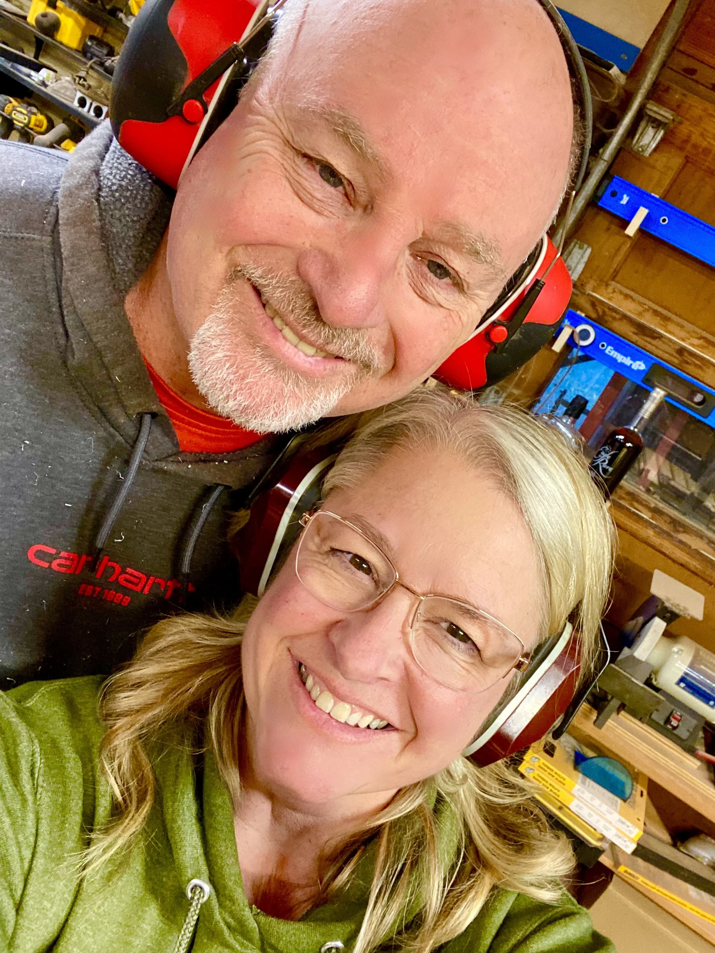 A selfie in a wood workshop with shelves of tools and supplies in the background.
