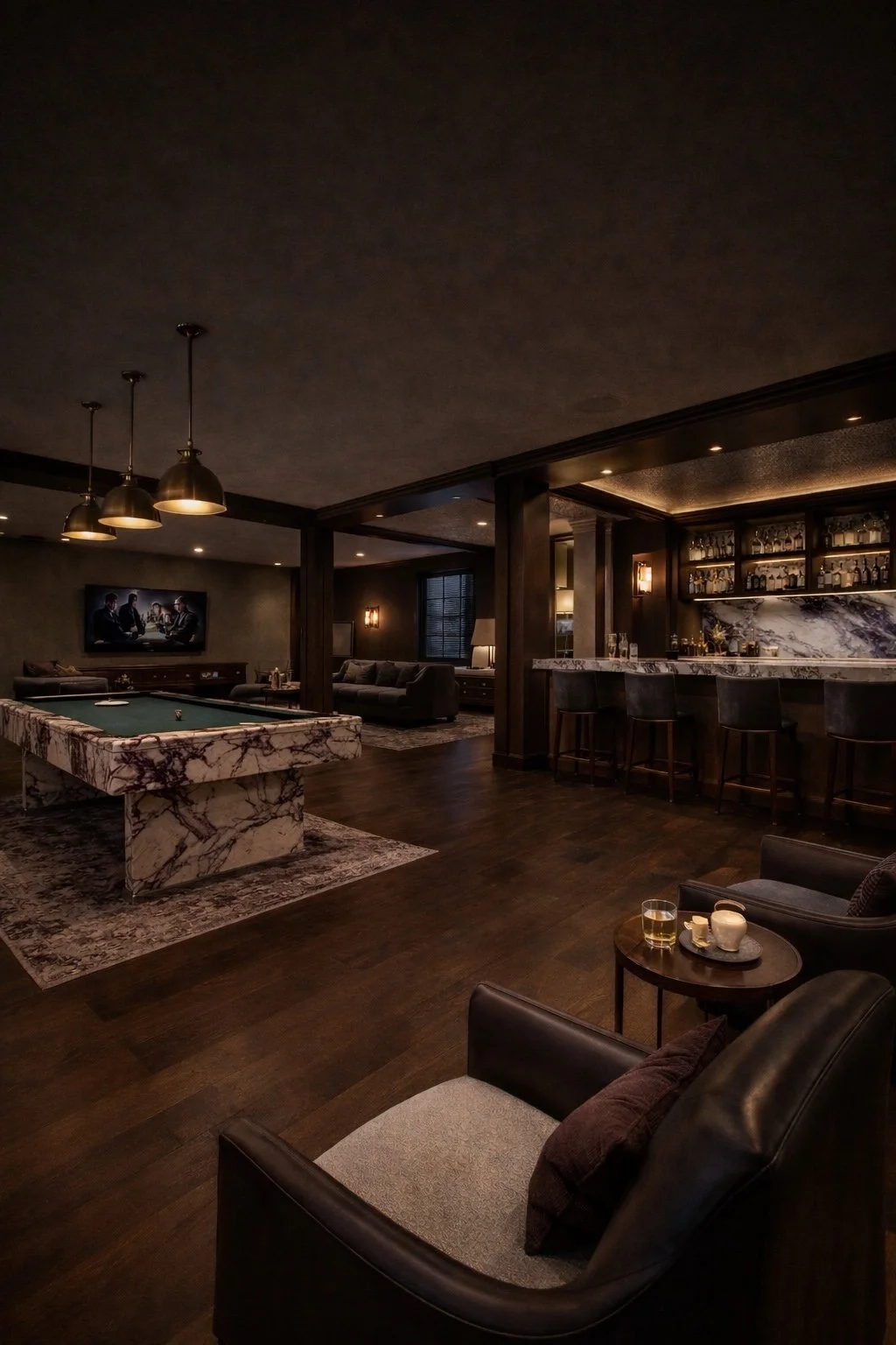 Luxurious dimly lit lounge with bar, pool table with marble top, seating areas with sofas and chairs, TV on wall, and a bar with barstools and shelves of bottles.