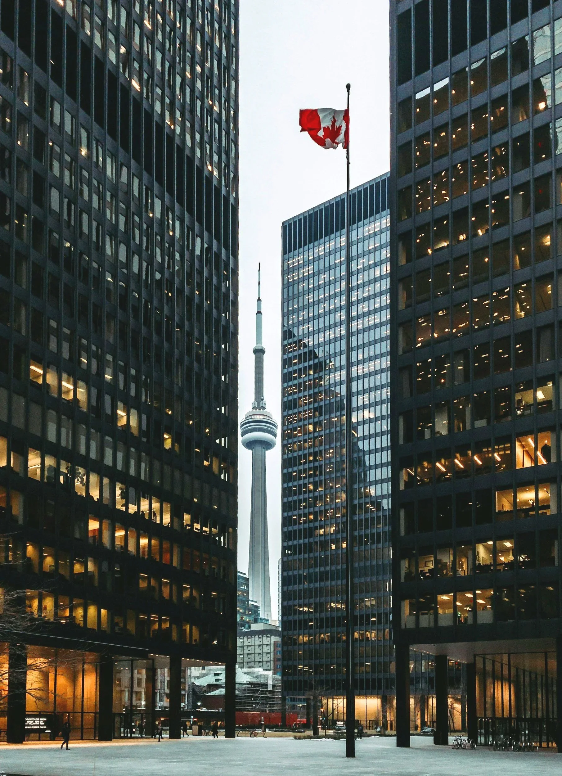 View of downtown Toronto with the CN Tower between two office buildings, one on each side, during evening hours.
