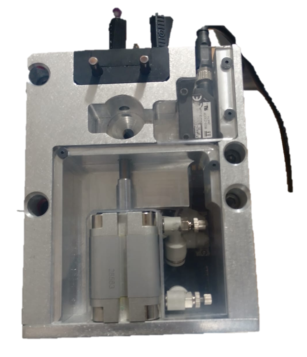 Metal mechanical device with hydraulic components, sensors, and fittings, used for industrial automation or manufacturing.