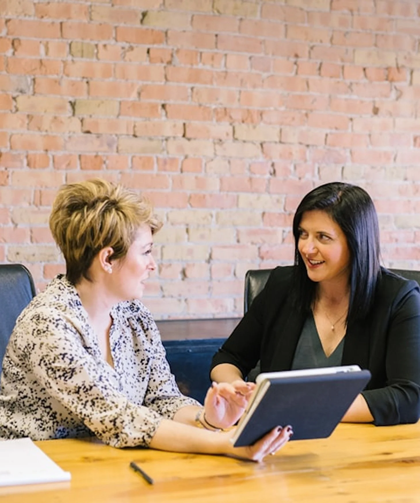 Two professionals in a modern office looking at a digital screen