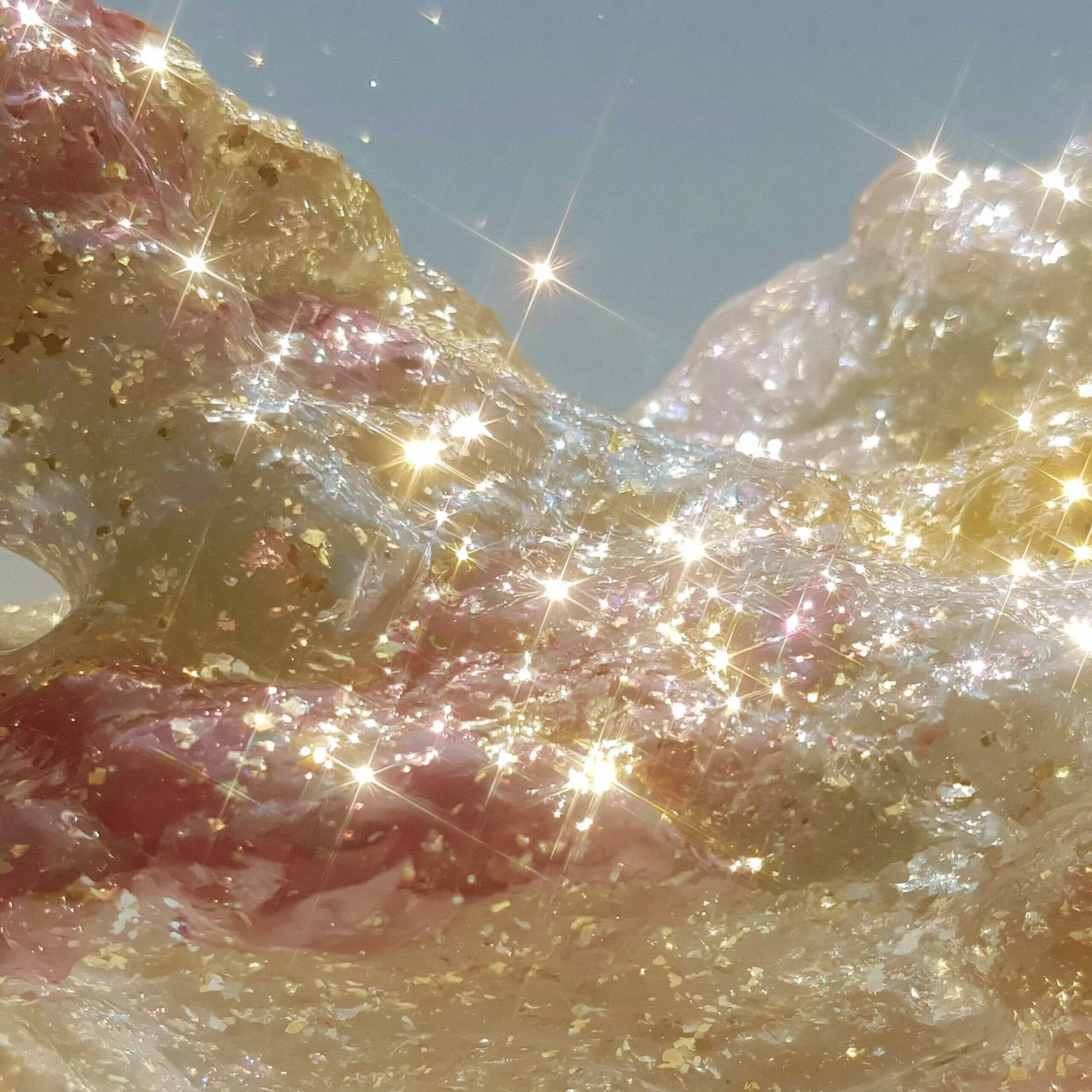 Close-up of gold and pink glittery objects with sparkling reflections.