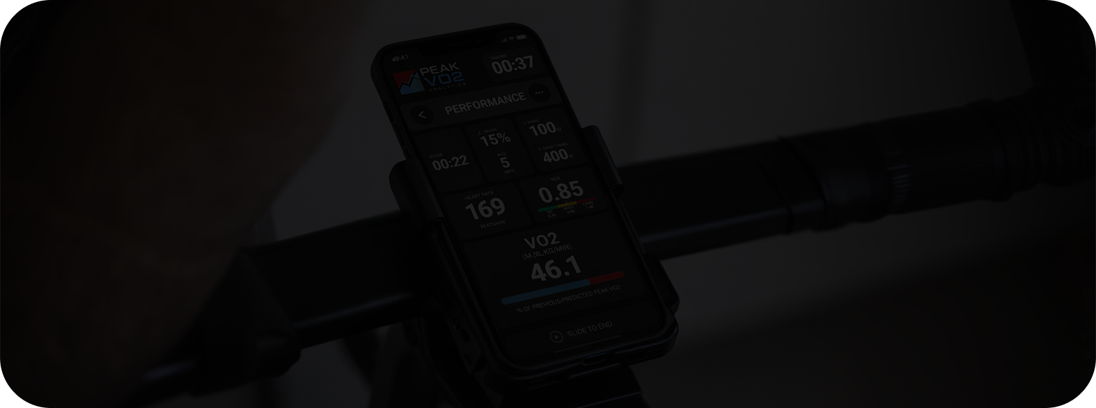 A smartphone mounted on a bike handlebar displaying performance metrics, including VO2, heart rate, and elapsed time, during a workout.
