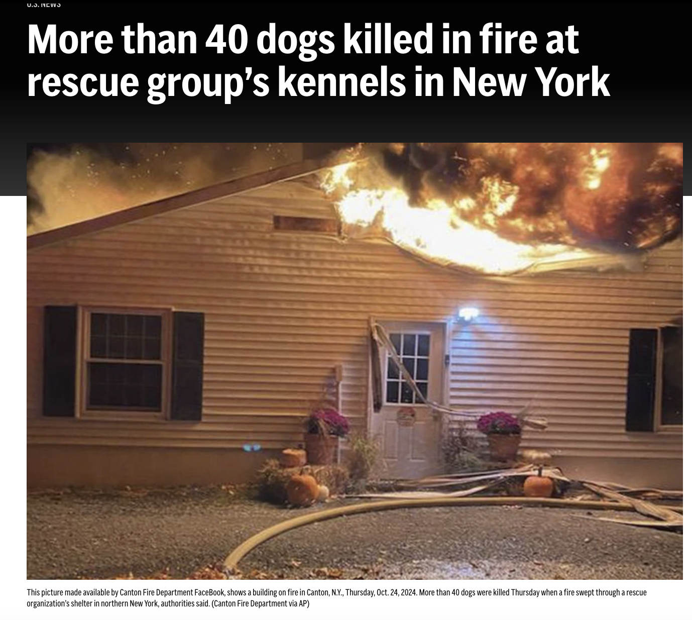 Building on fire in Canton, New York, with flames and thick black smoke coming from the roof, and rescue hoses on the ground in front.