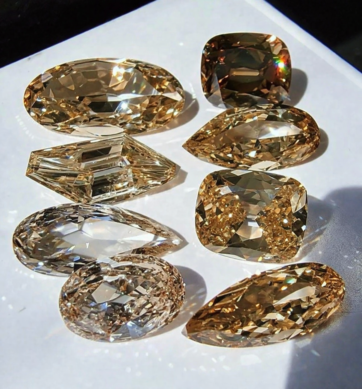Sparkling gemstones on glossy white surface.png