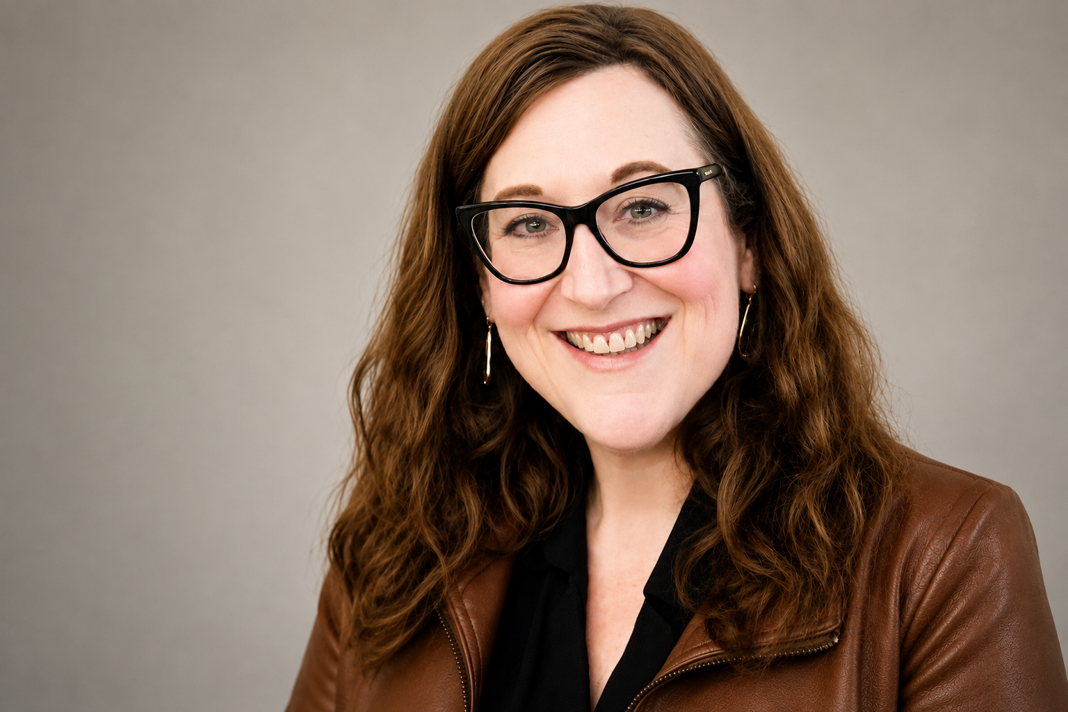 Middle-aged woman, brown hair, glasses, brown jacket