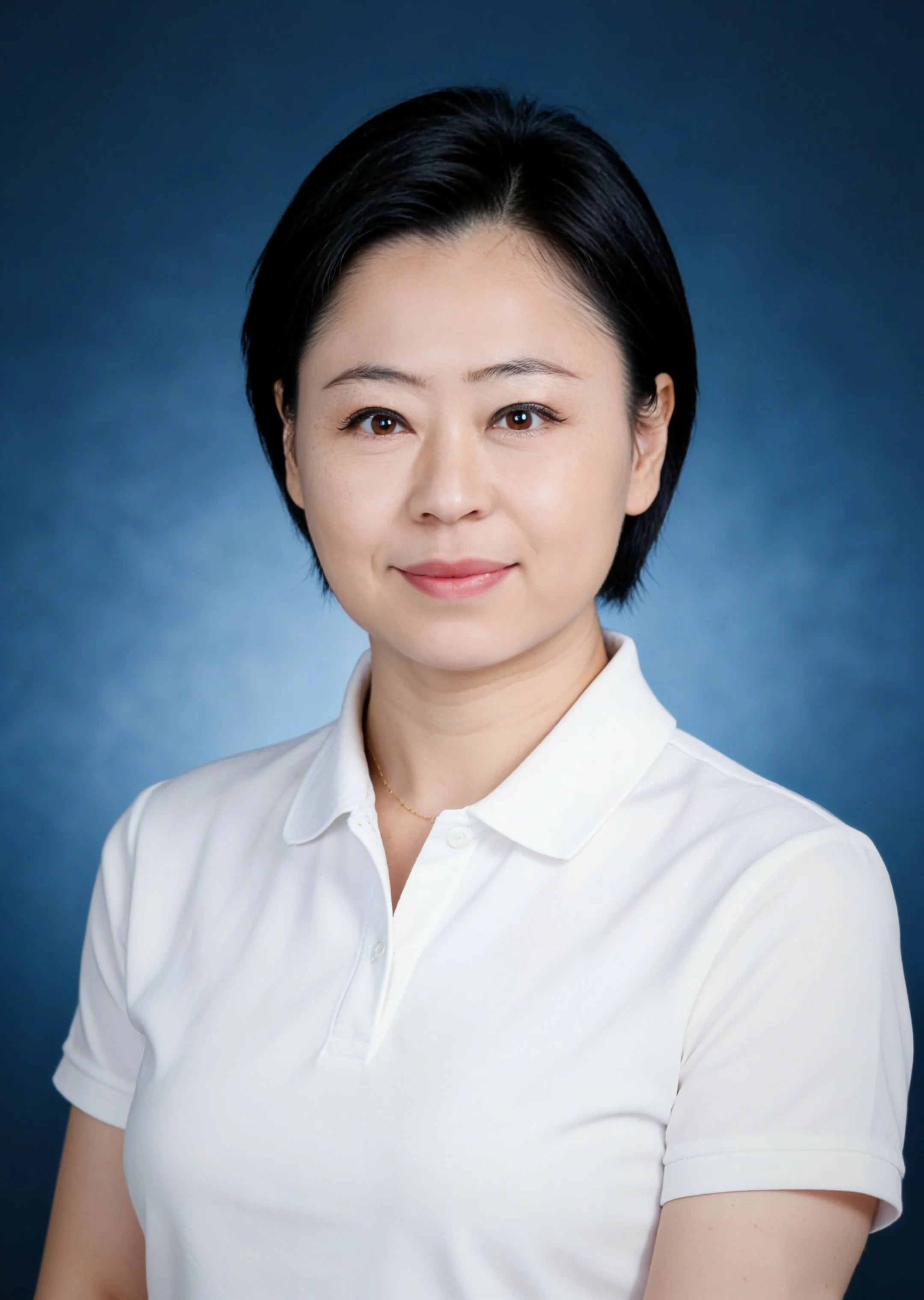 A woman with short black hair, wearing a white polo shirt, smiling softly, against a dark blue background.