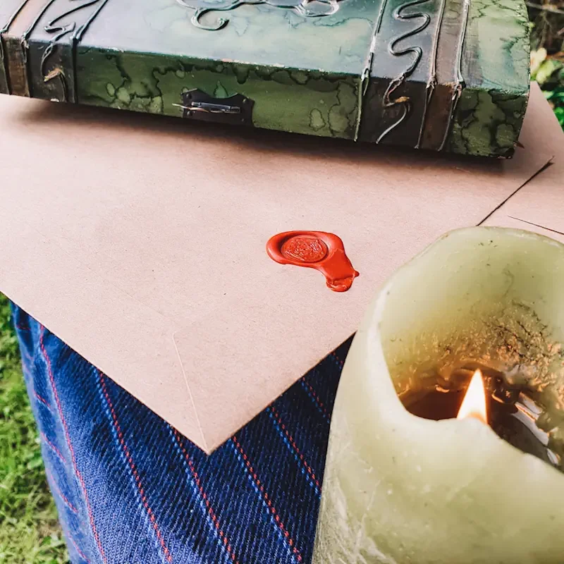 Wax sealed envelope in a wooden chest, candle