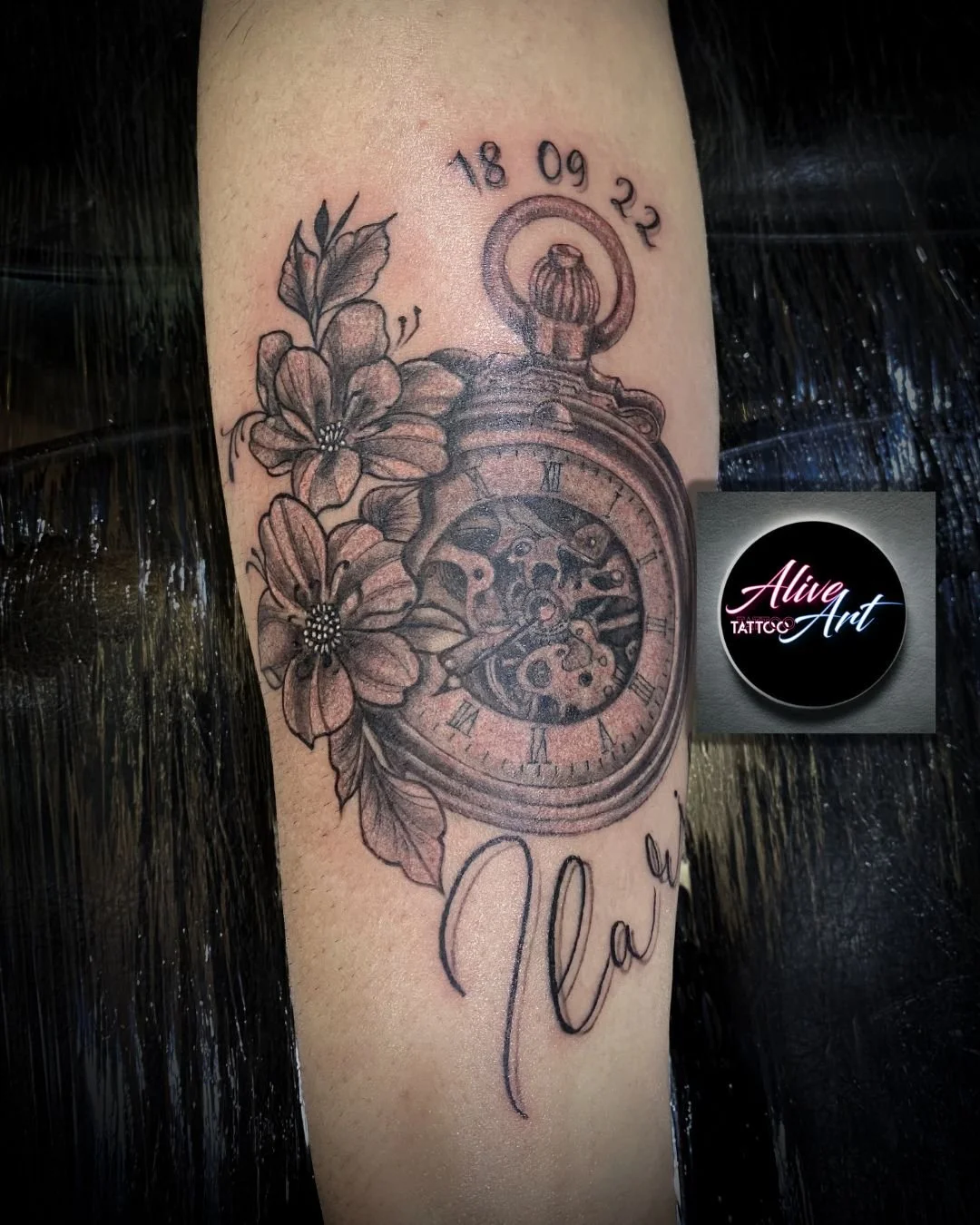 Tattoo of a pocket watch with floral accents, the date 18 09 22, and the word 'Nan' written below.