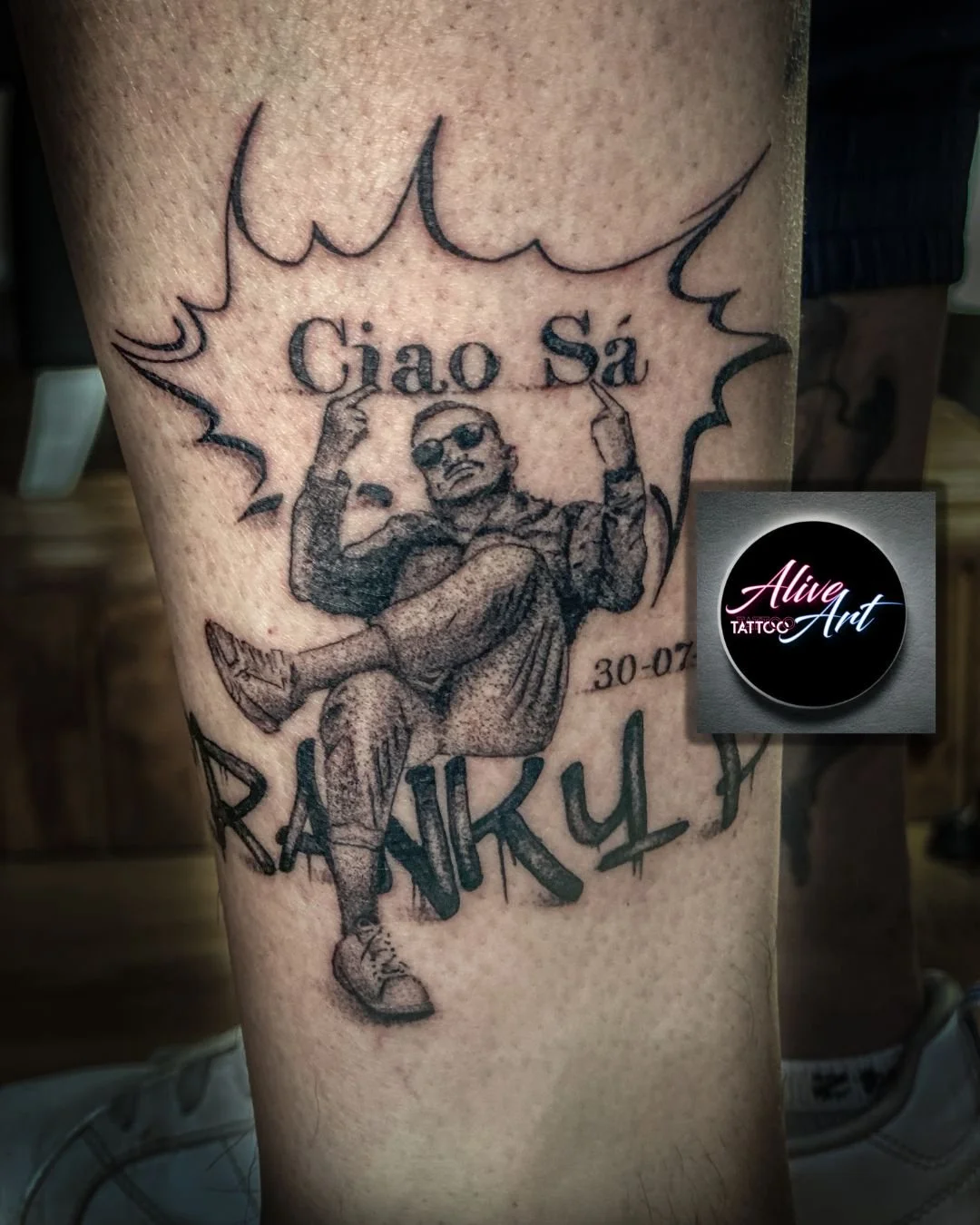 Tattoo of a standing man with sunglasses, crossing his arms, with the words 'Ciao Sá', 'RANKYK', and the date '30-07' around him.