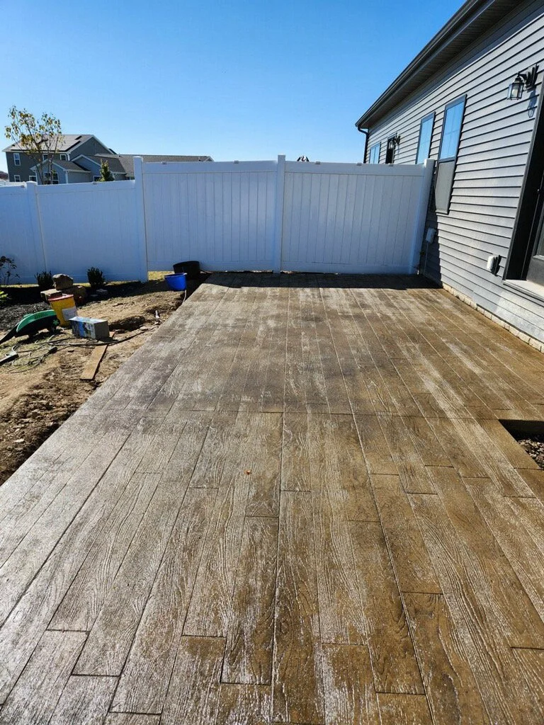 Newly installed stamped concrete with wooden plank design.